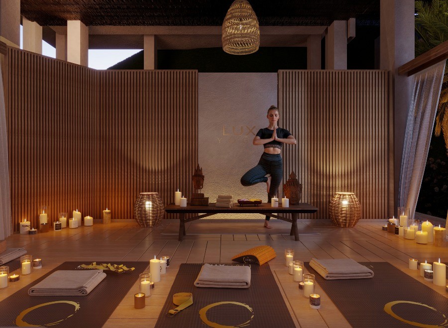 A woman practices yoga in a serene room illuminated by soft candlelight