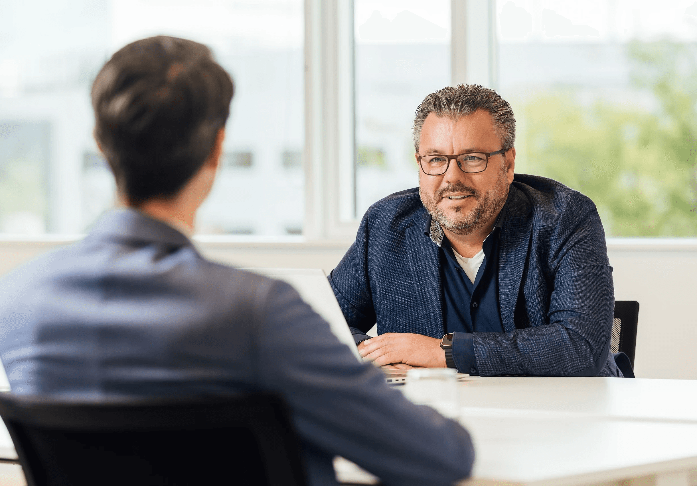 Two people sitting across a table talking
