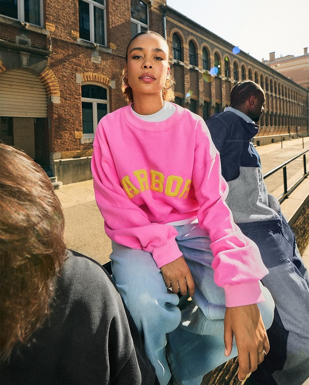 Une mannequin porte une maille rose siglée "Arbor"