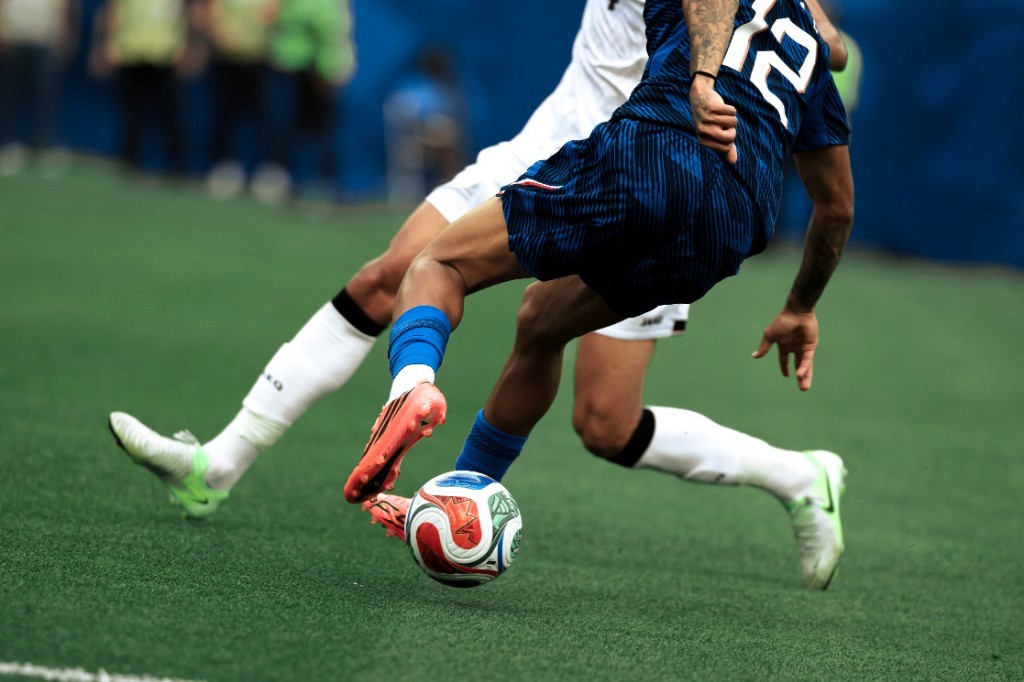 A France attacker shields the ball from an Iraq defender during World Cup 2026 group play