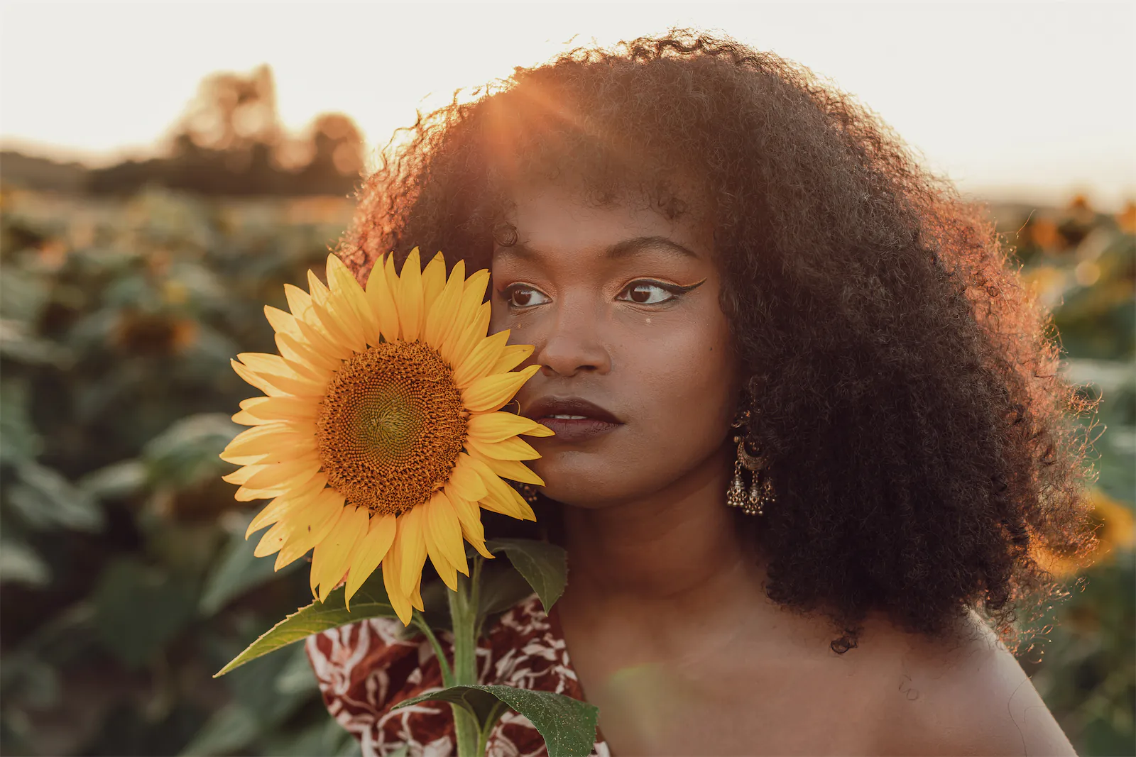 Femme dans les champs avec un tournesol dans la main