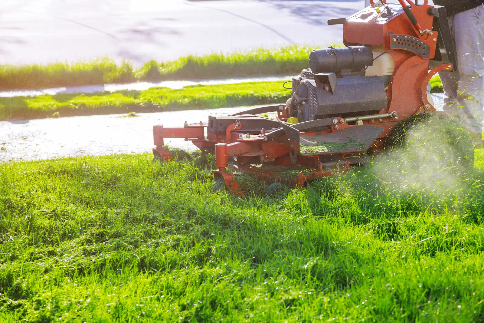 worker mowing lawn with professional grade mower