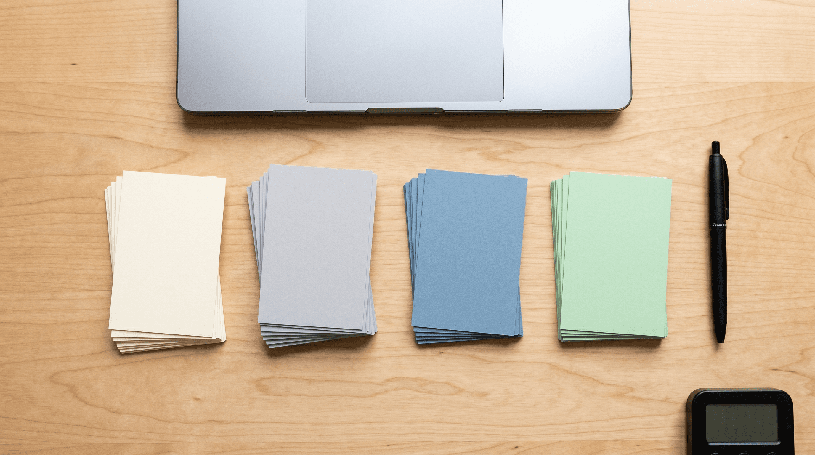 Desk with paper cards grouped into four workflow piles