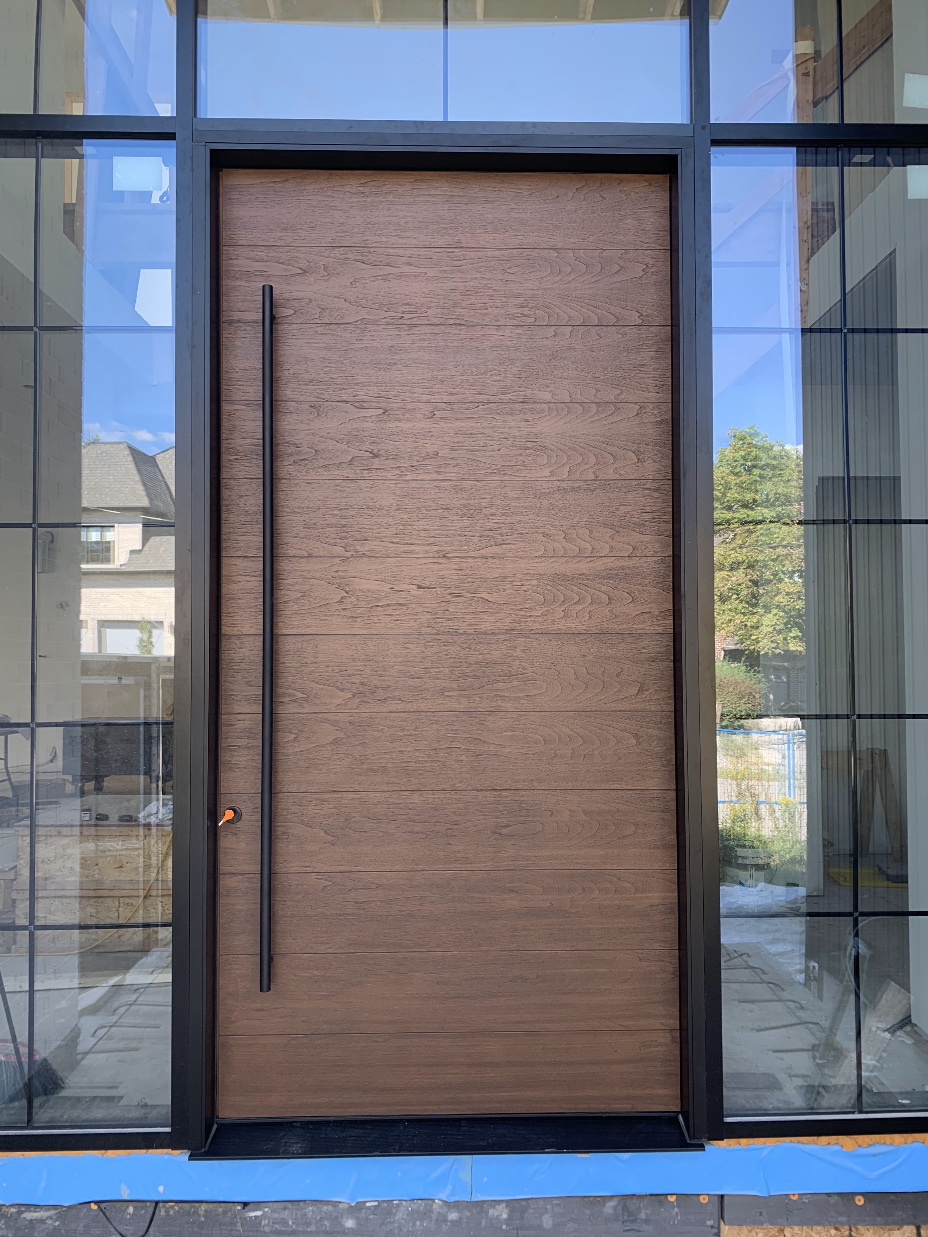 Premium hardware finish in brushed brass on a contemporary custom-built front door.