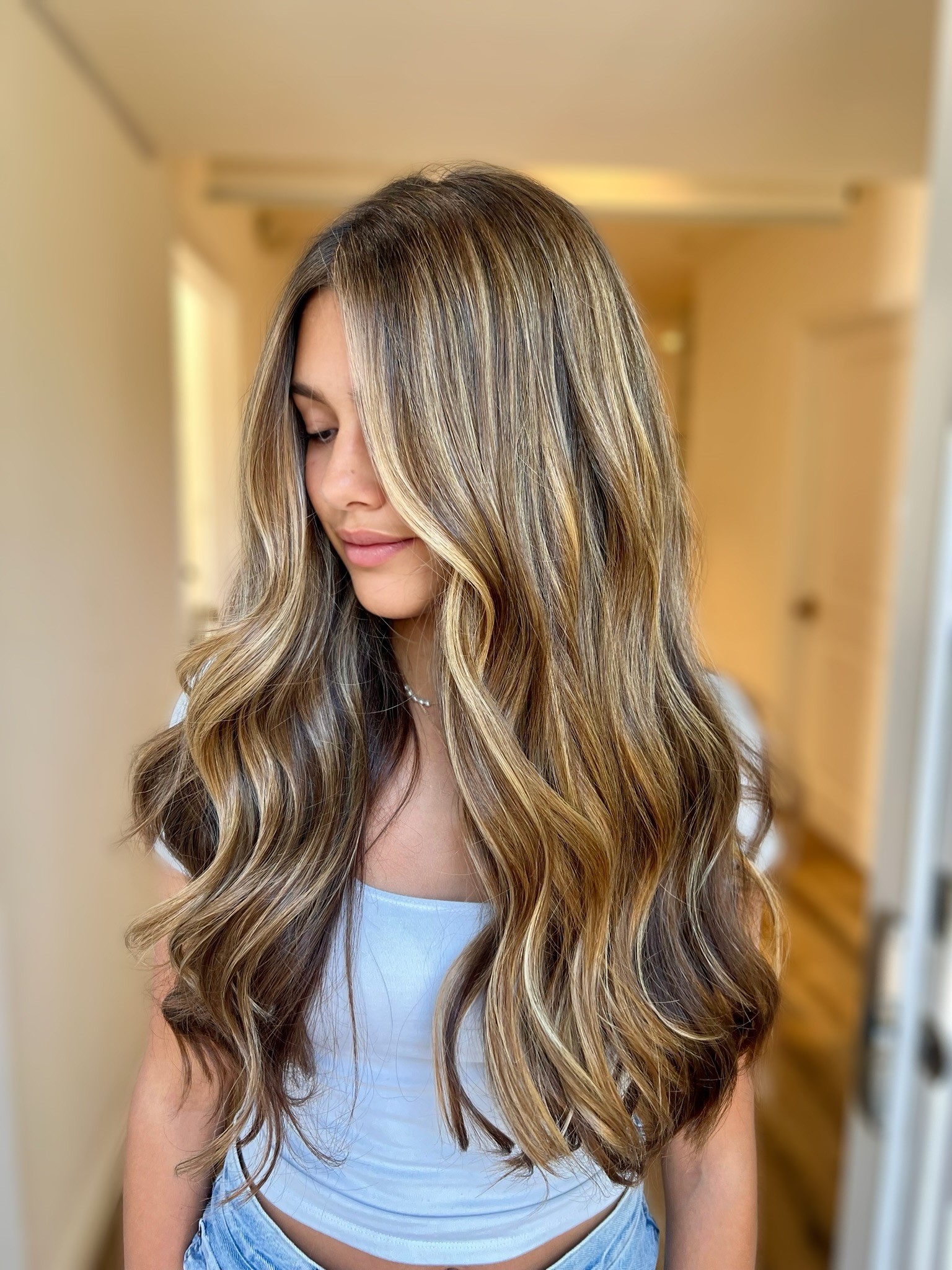 Face-framing blonde highlights at Bomane Salon, Beverly Hills – blended highlights for thick, healthy hair.