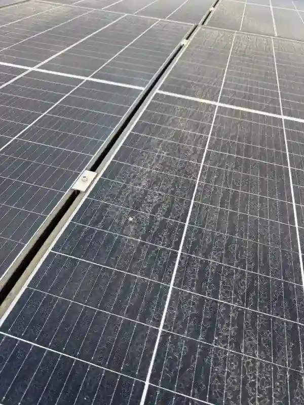 Prim-plan cu panouri fotovoltaice acoperite de praf, înaintea curățării profesionale