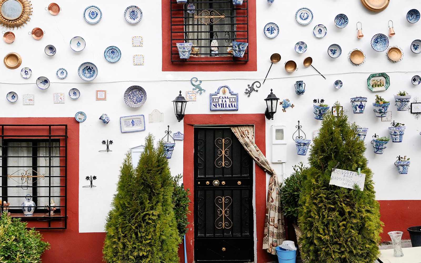 Colorful ceramic plates and pots on a white wall in Albaicin, Granada.