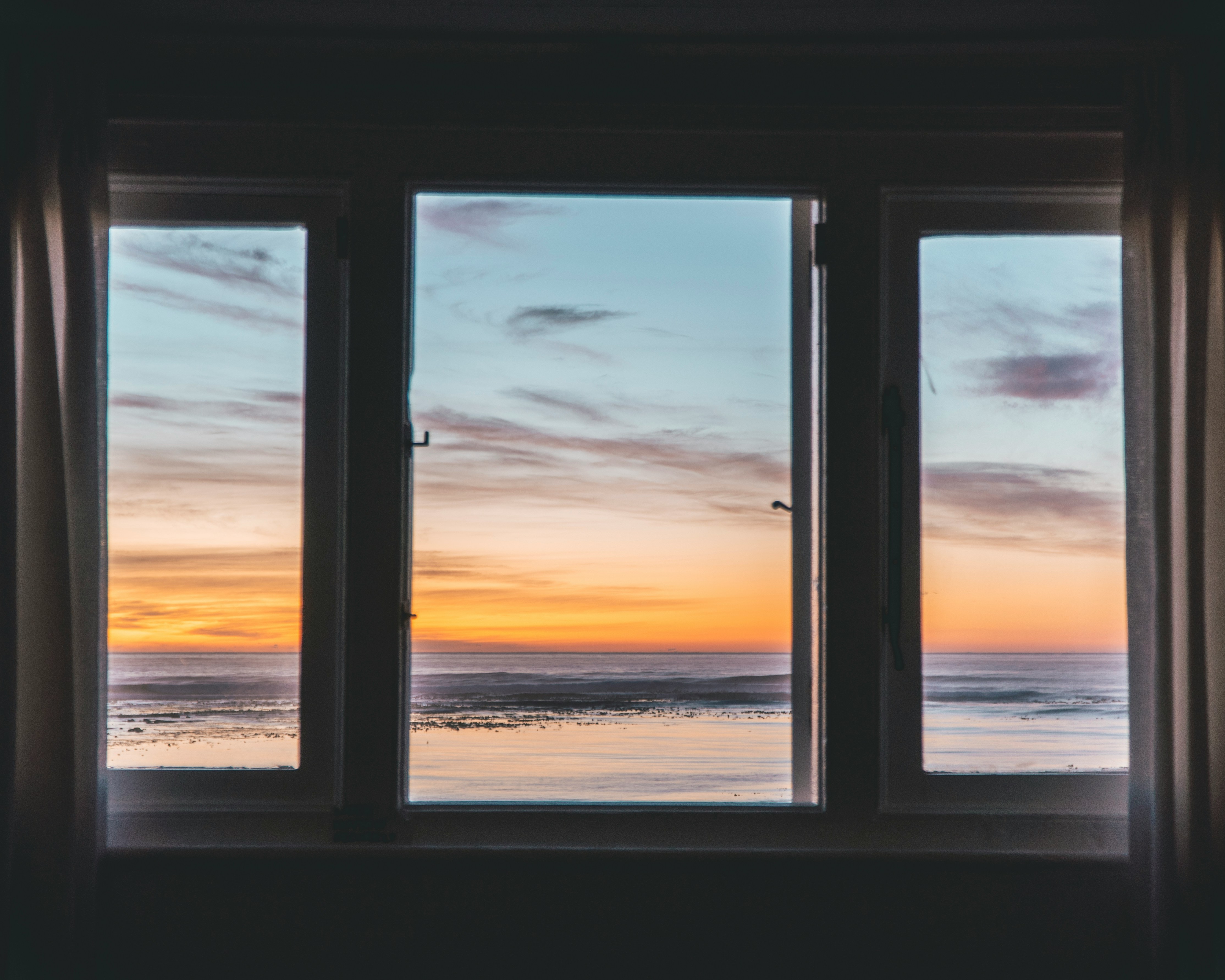 Beach sunset viewed through a window.