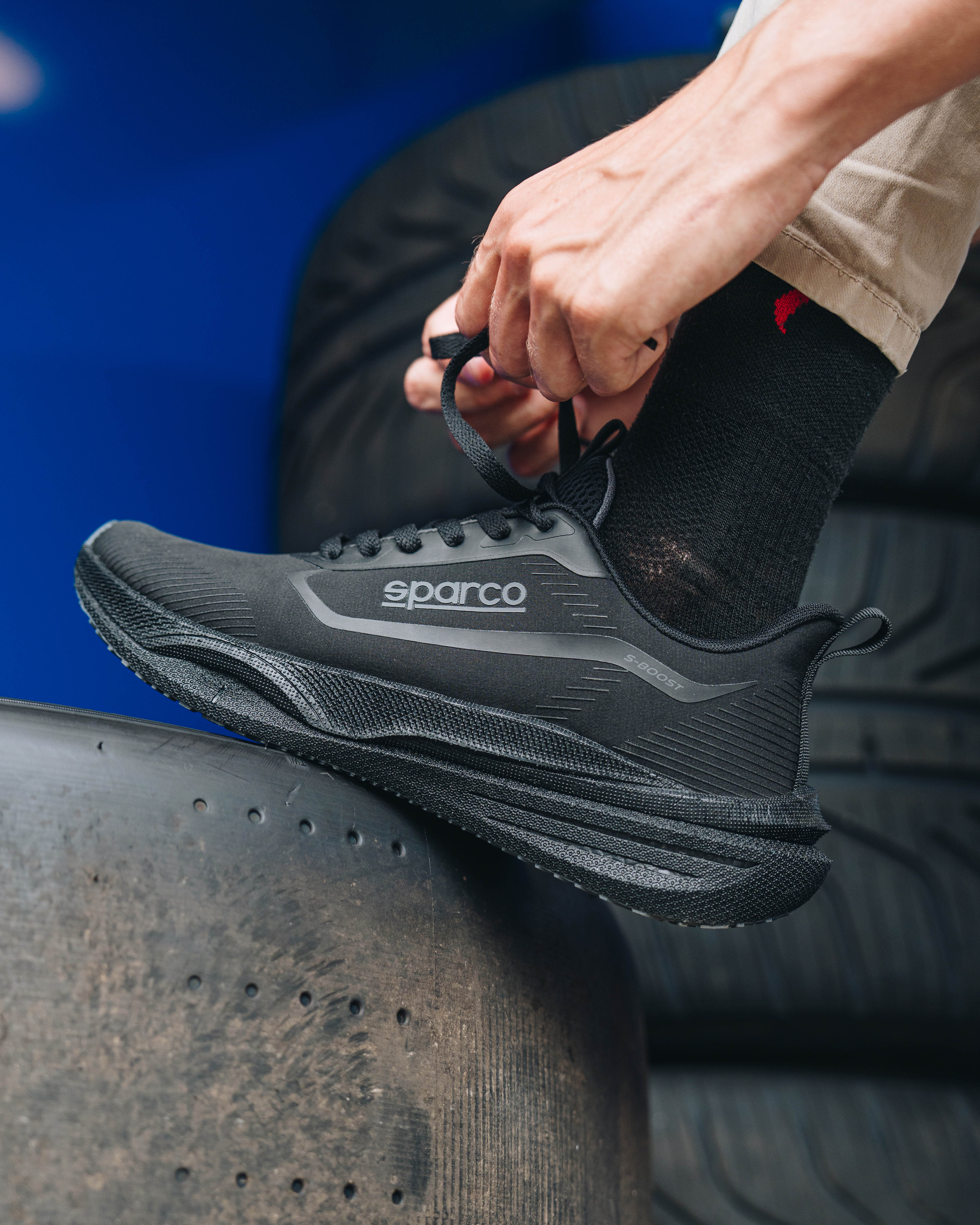 Render vista tre quarti frontale di Kia EV6 in ambiente architettonico moderno e minimalista in stile advertising.