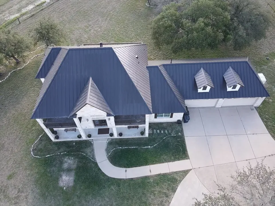 Finished dark standing-seam metal roof with twin dormers, New Braunfels 2025