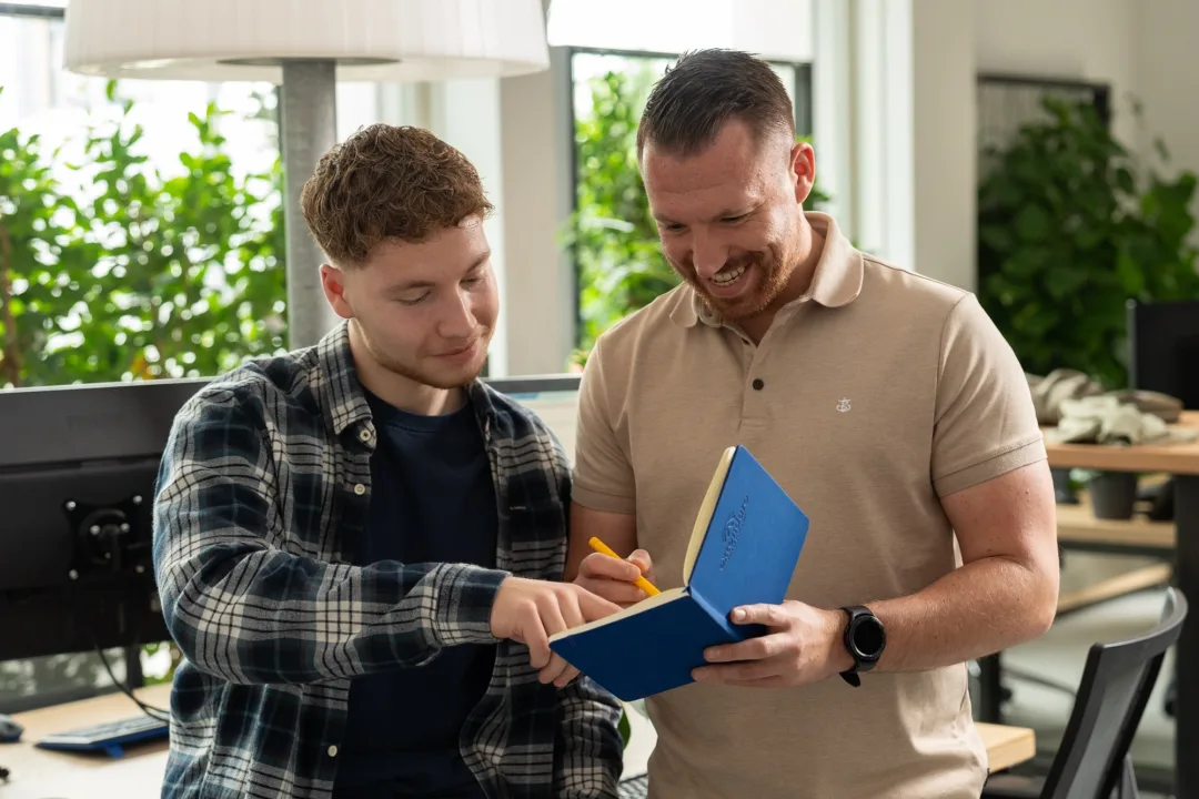 Twee collega's die samen iets noteren