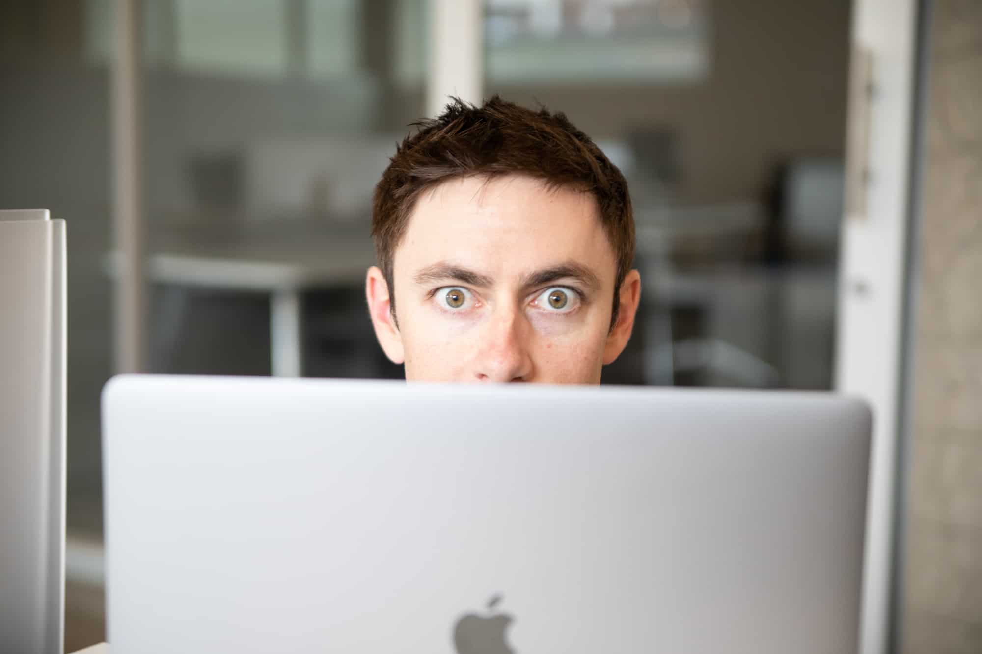 Man looking stressed while working on SEO with laptop