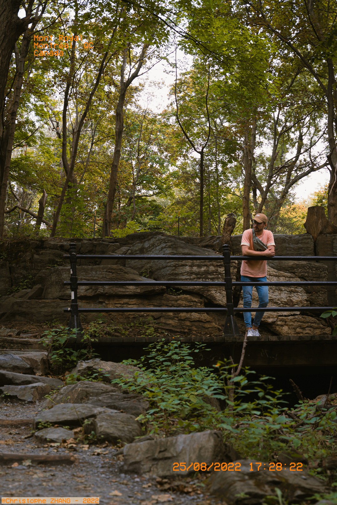 Personne posant sur un pont entouré de verdure dans le Parc du Mont-Royal.