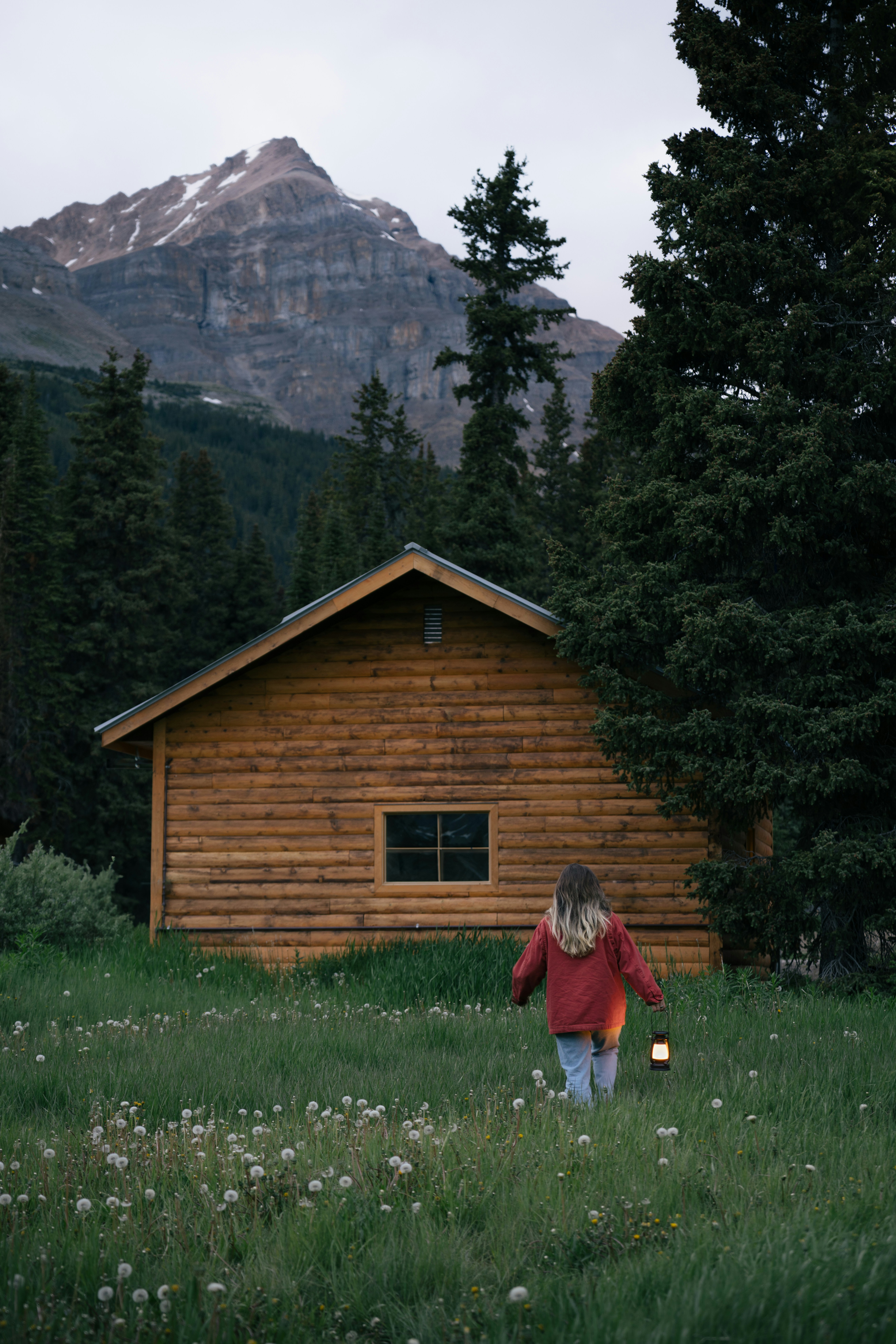 A girl walks to a cabin in nature.