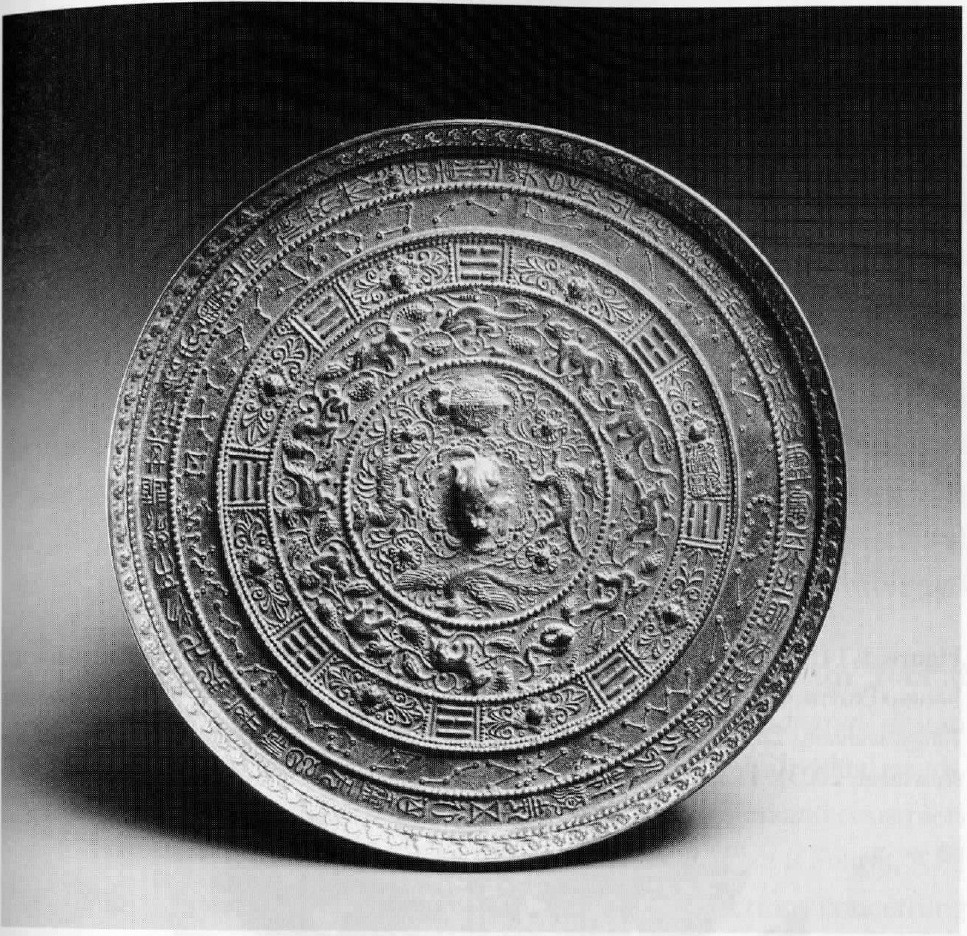 Tang bronze mirror with concentric cosmological motifs and inscriptions.