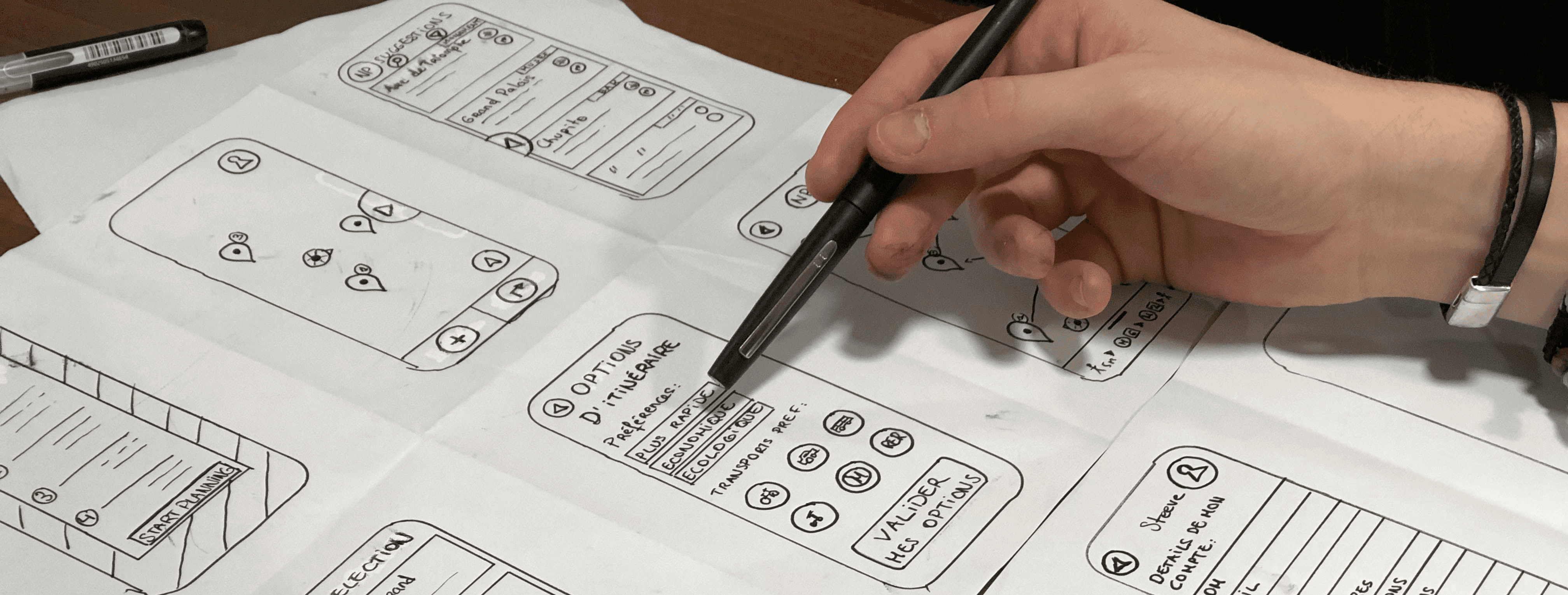 person holding pen near paper
