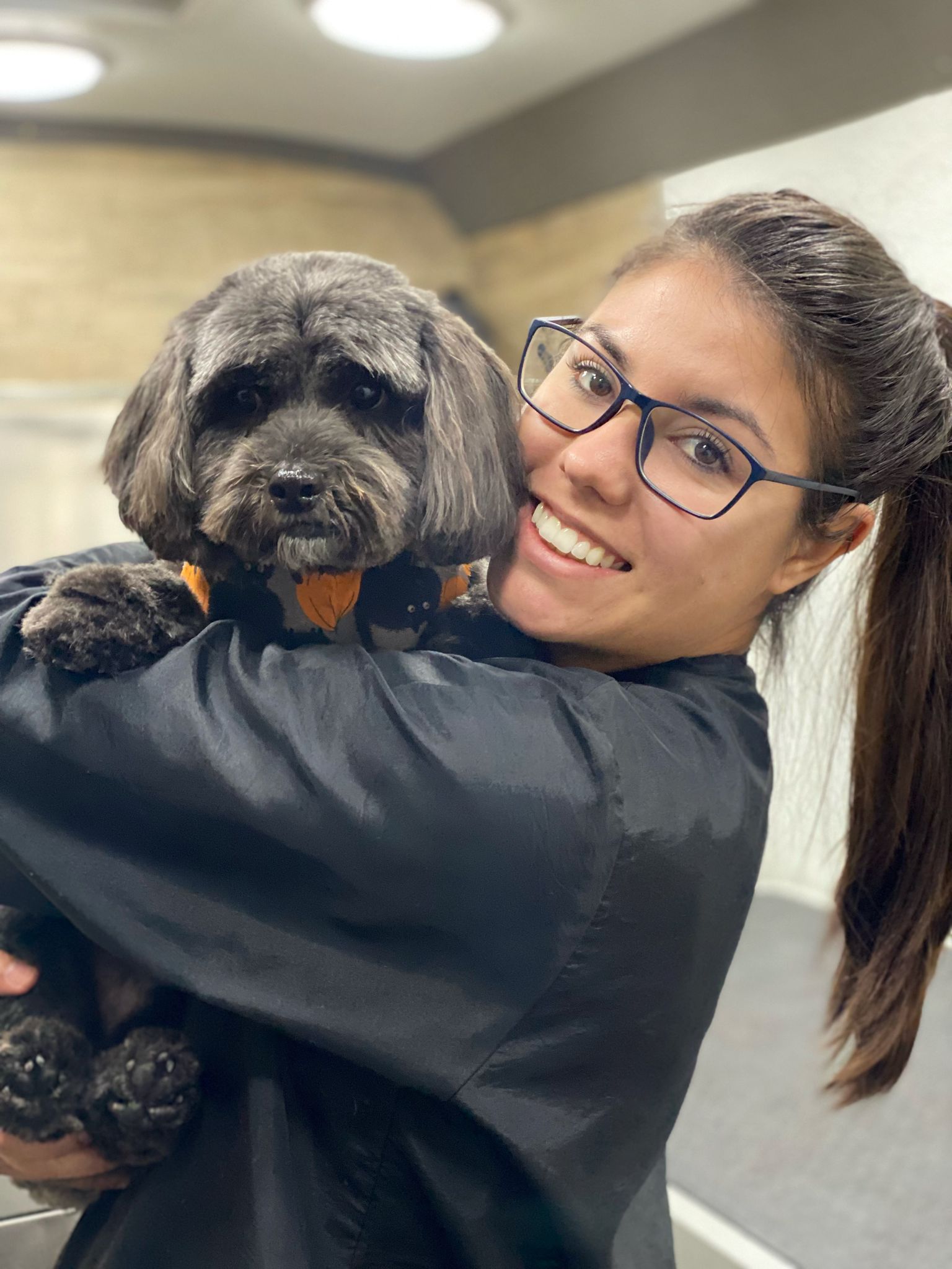 Amanda Groomer holding a black dog