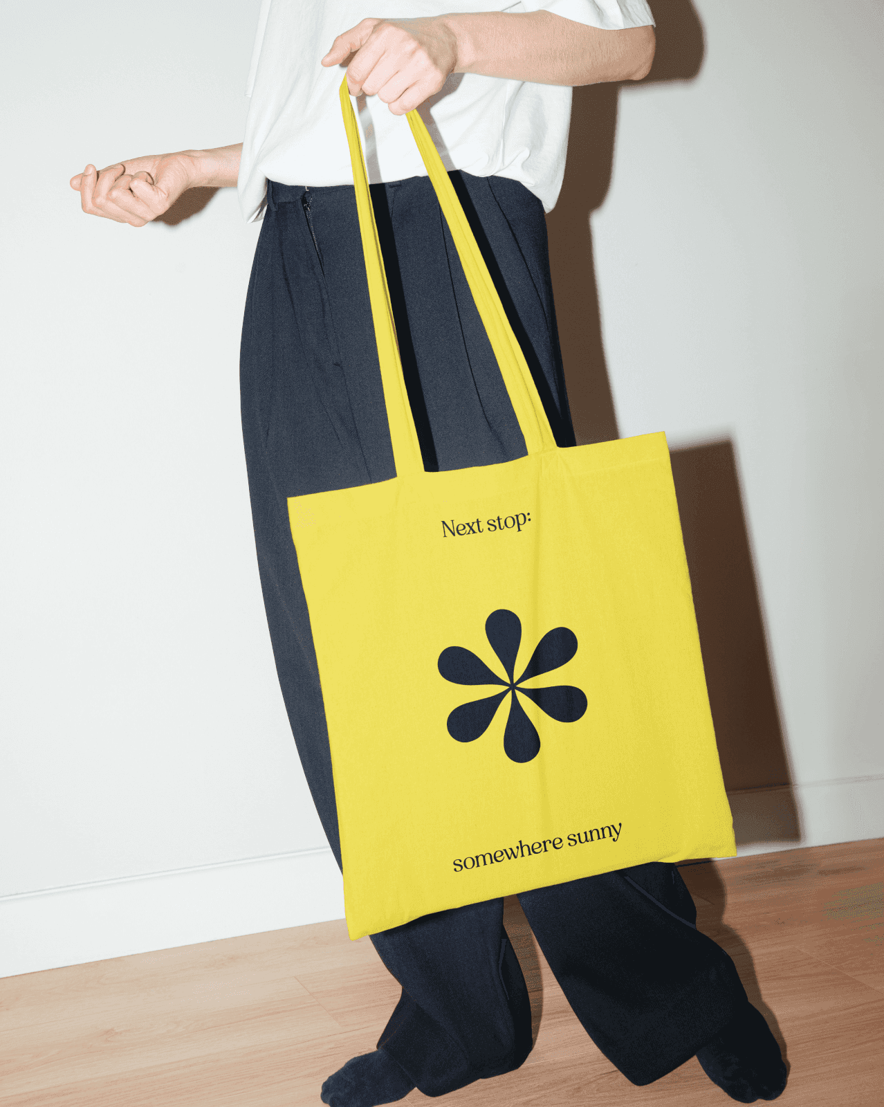 Bright yellow tote bag with the text "Next stop: somewhere sunny" and a Penny logo