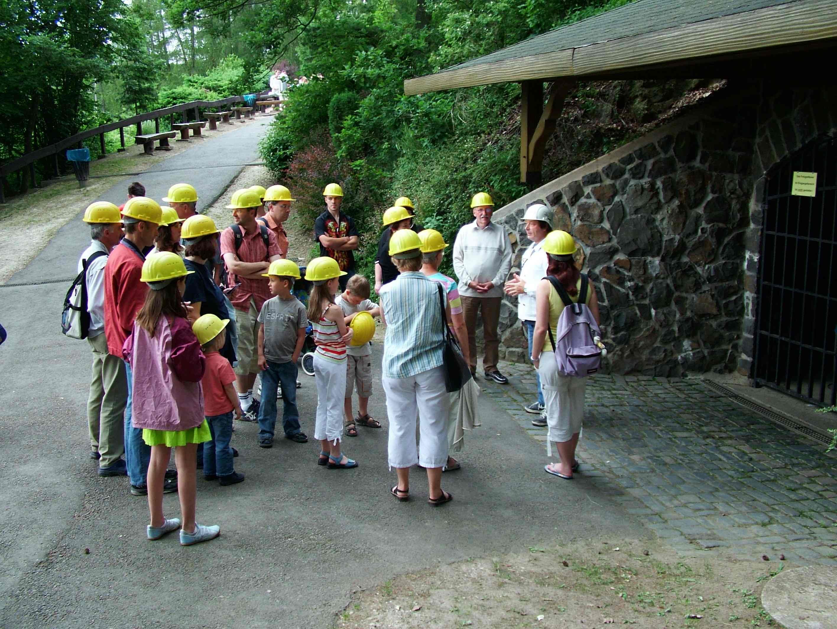 Visitors with hard hats in front of the entrance of the Steinkaulenberg gemstone mine
