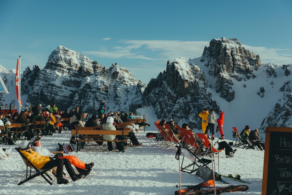 Skiers relaxing on a snowy mountain with scenic alpine views.