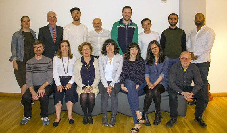 A photo of a group of people in an art exhibition room.