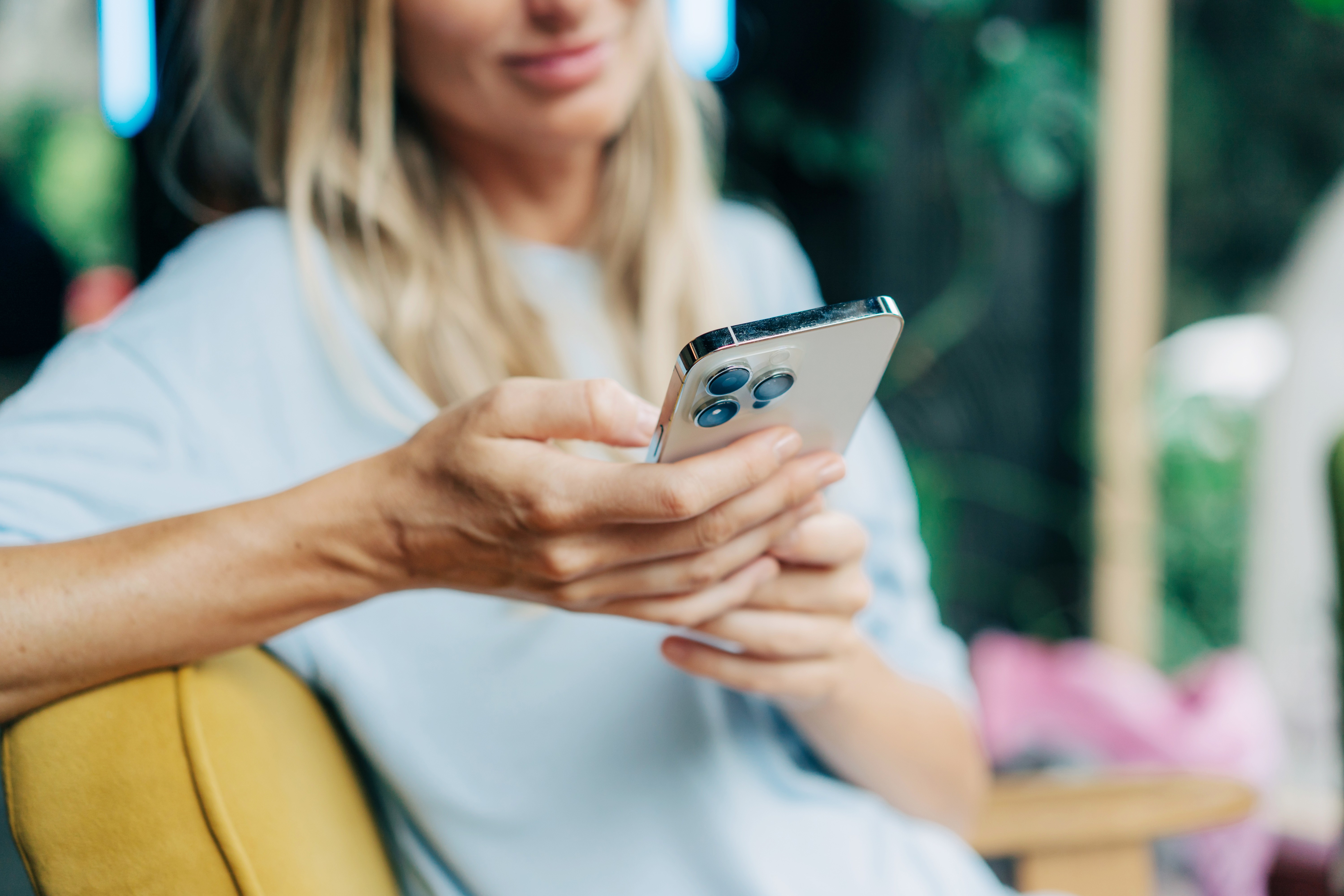 Smiling woman using the Albert Heijn app while sitting on a couch