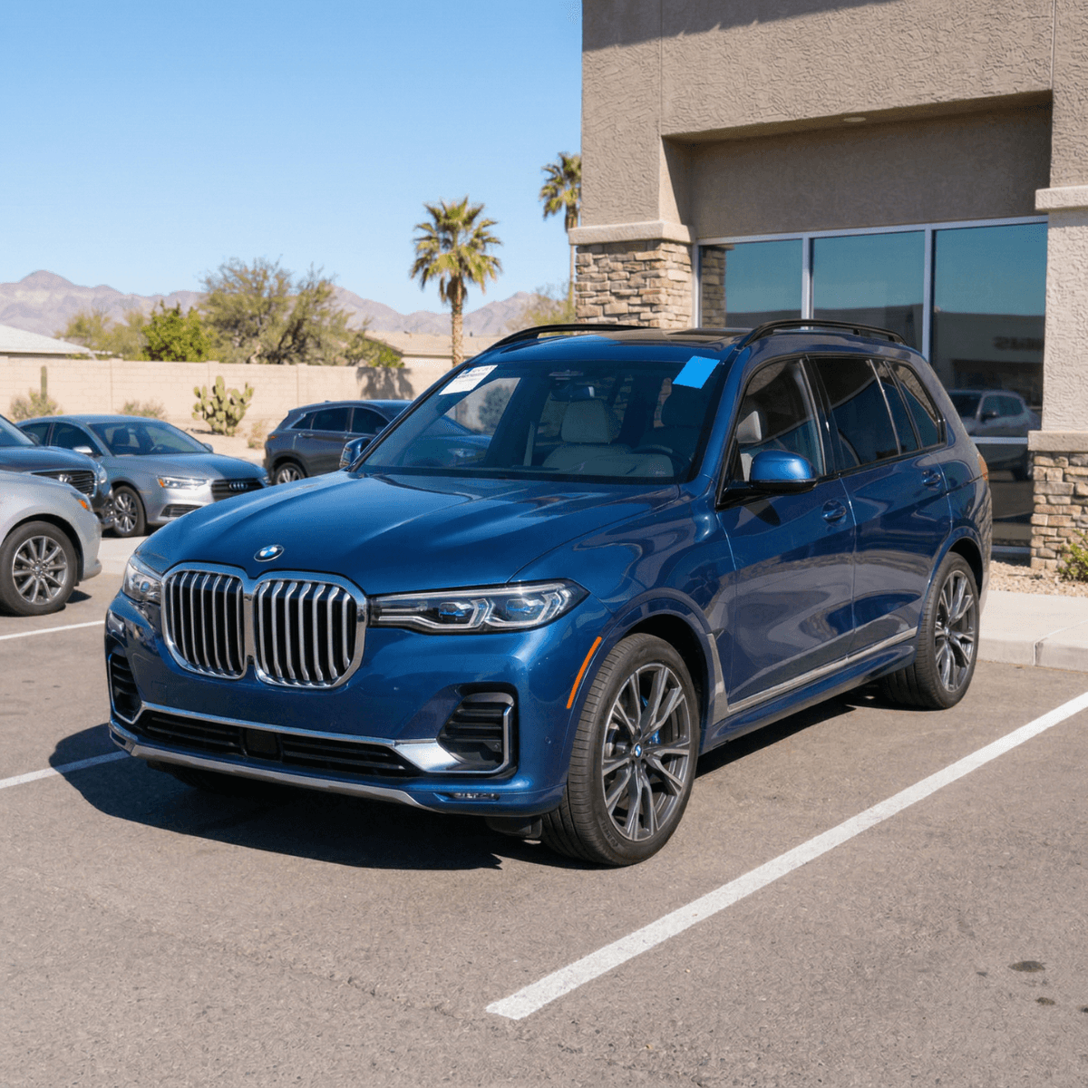 Mobile windshield repair on a blue BMW X7 at a Wellton, AZ business park parking lot