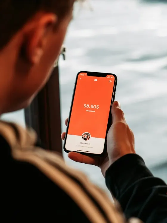 A person holding a phone showing an activity app
