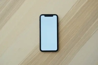 Uno smartphone con lo schermo vuoto su un tavolo di legno