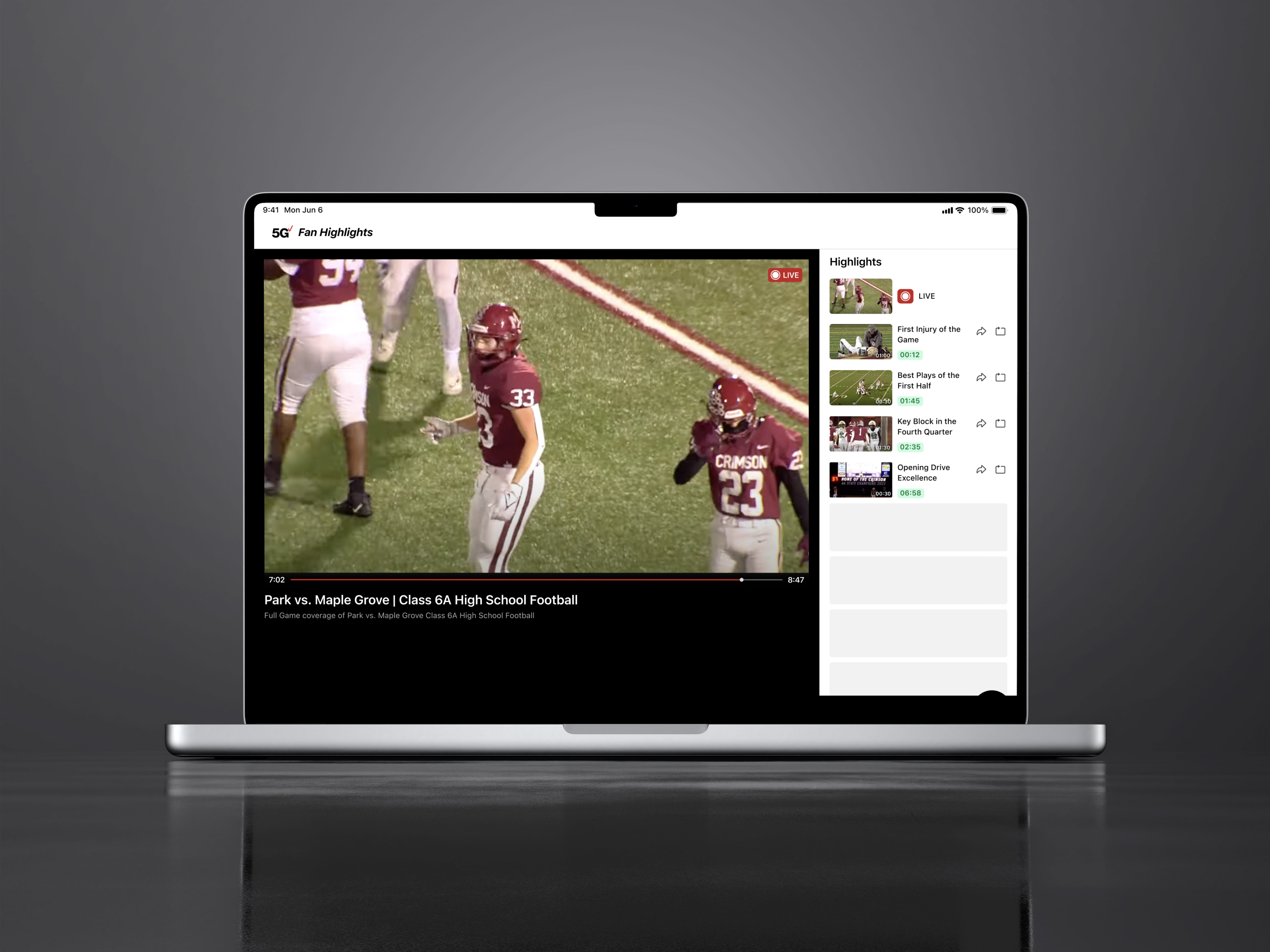 Red trolley car driving down a tree-lined street.