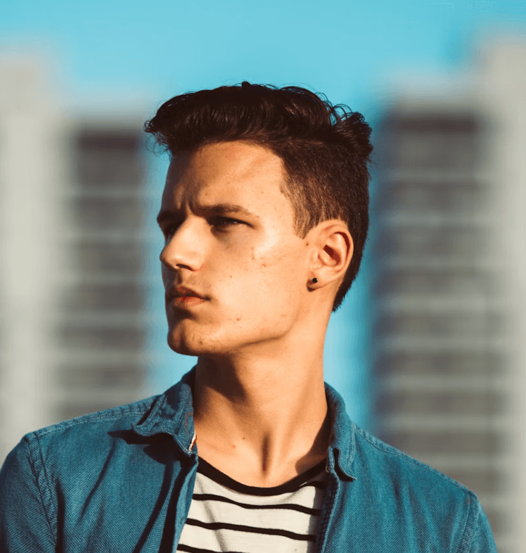 Jeune homme brun dehors dans une ville