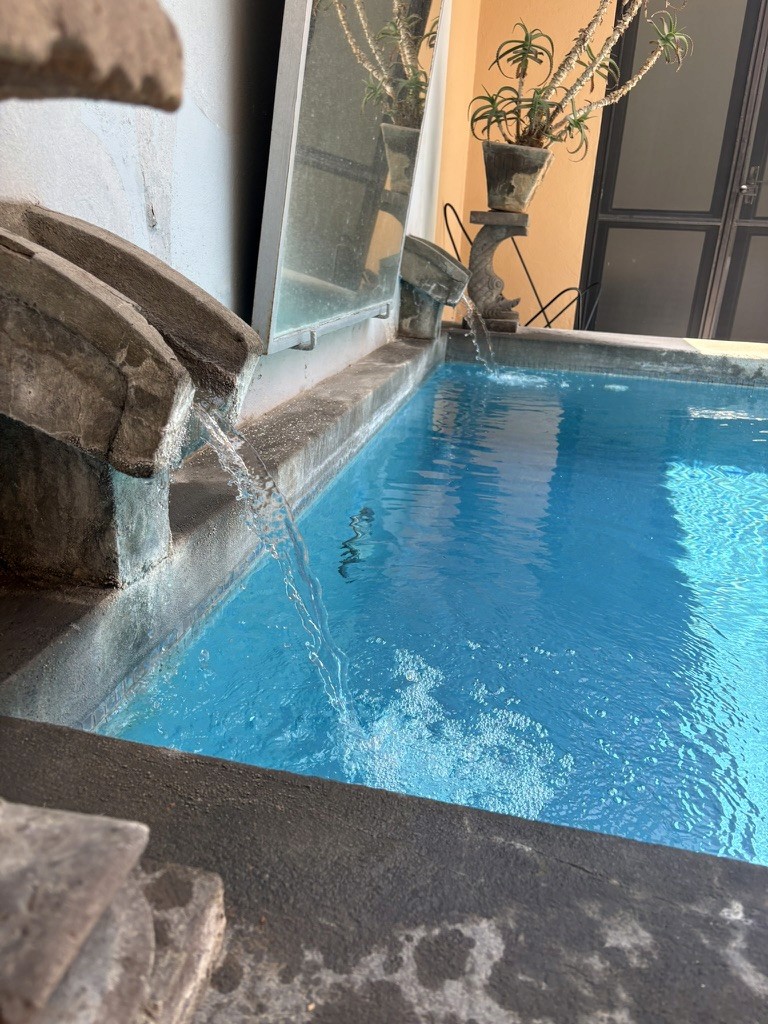 Flowing water into the bright blue pool at Casa de los Tíos