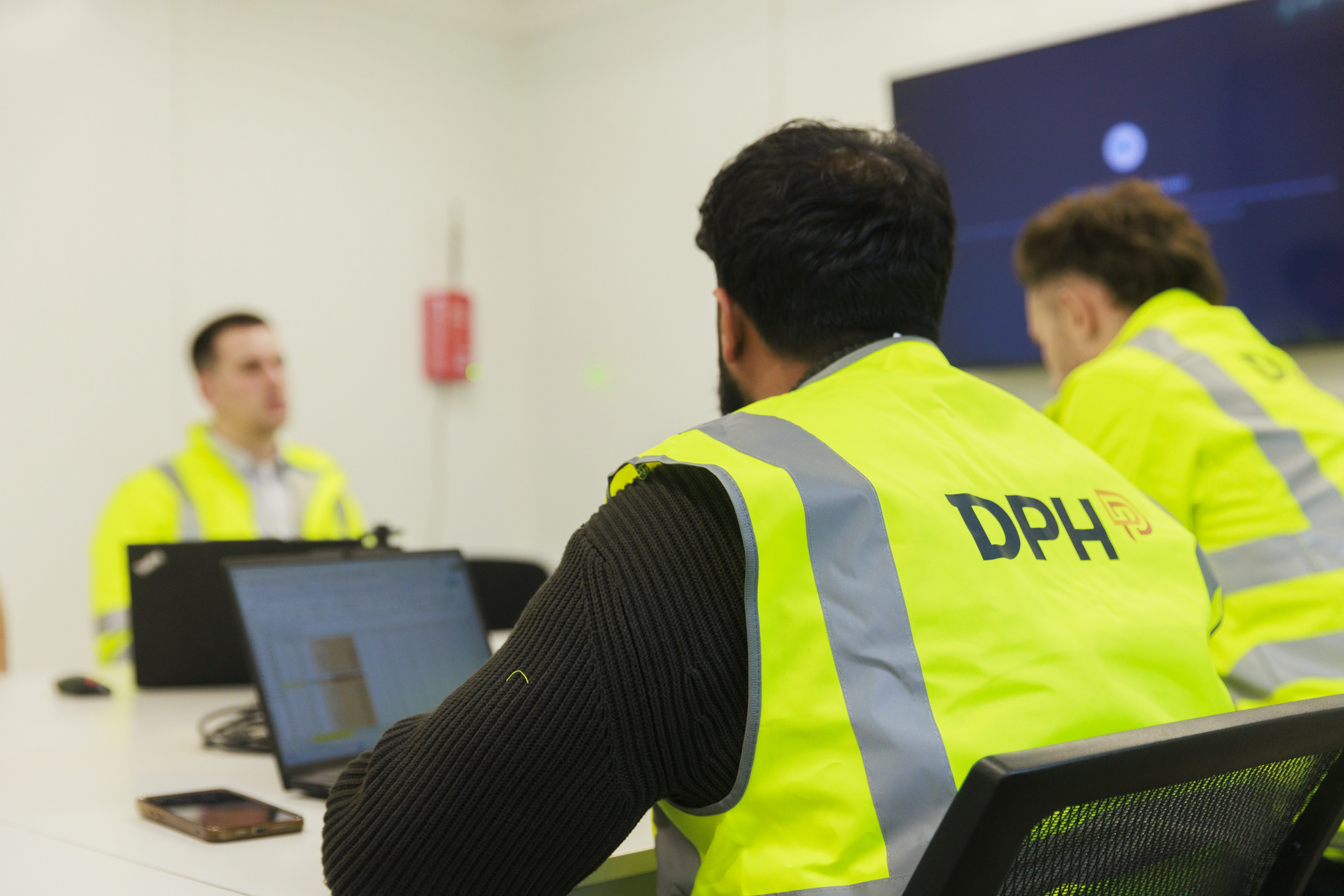 Entrance of a modern glass building with illuminated facade and reflections