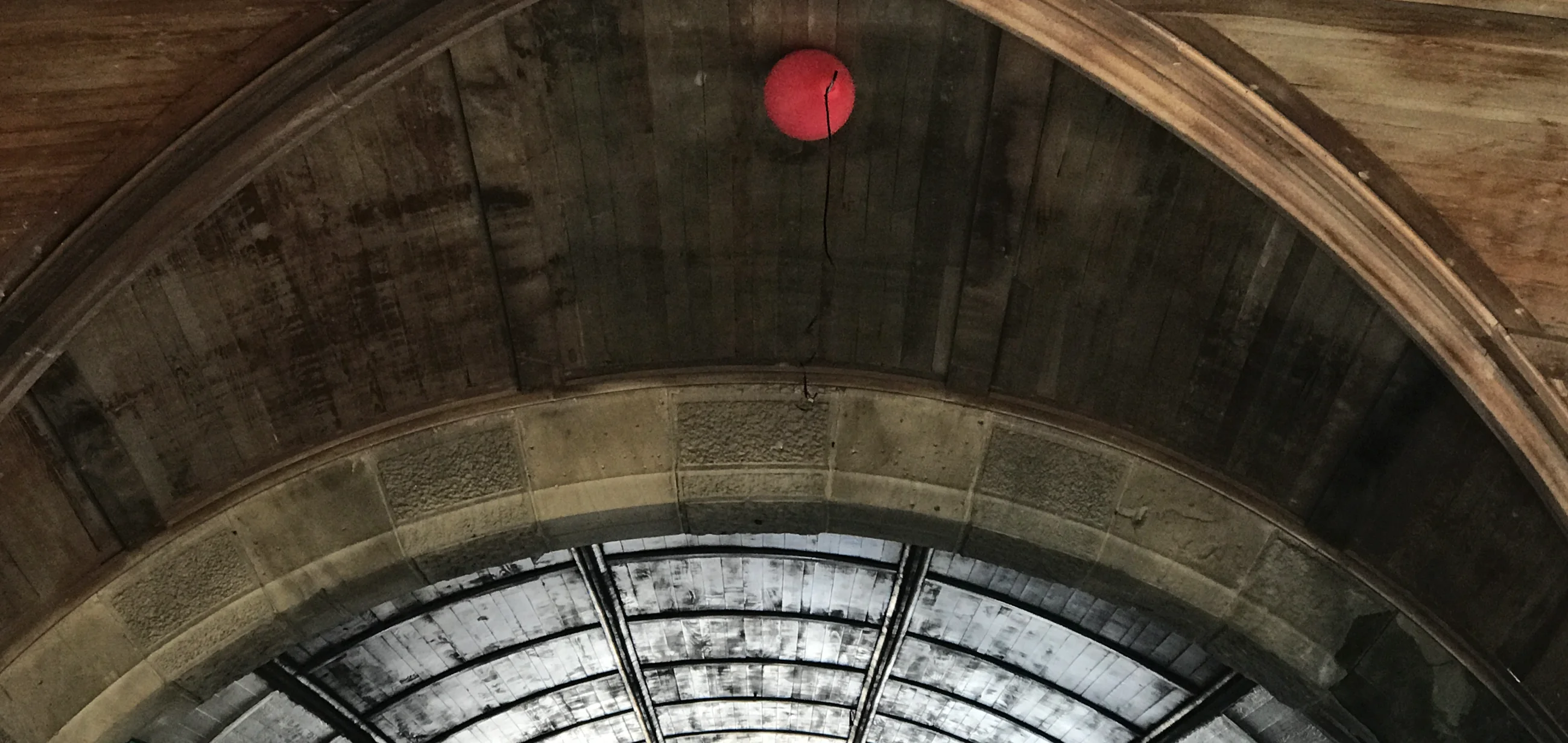 Red balloon under a vaulted stone arch