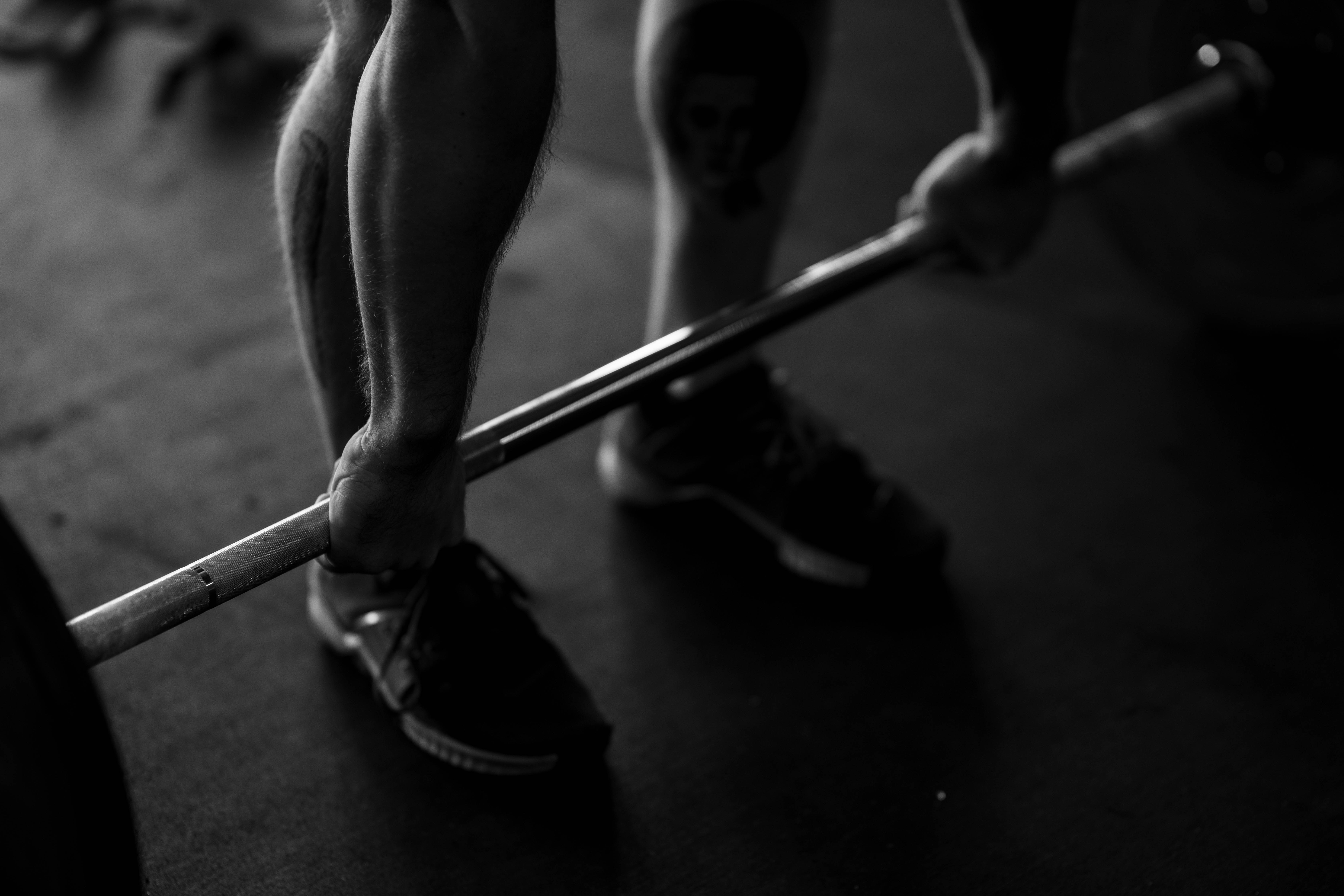 woman in white tank top and black shorts holding bar