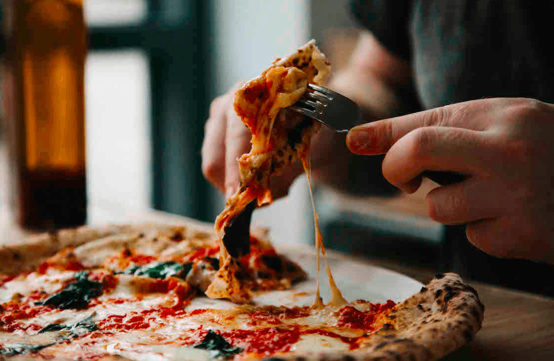 Slicing a Rudy's pizza