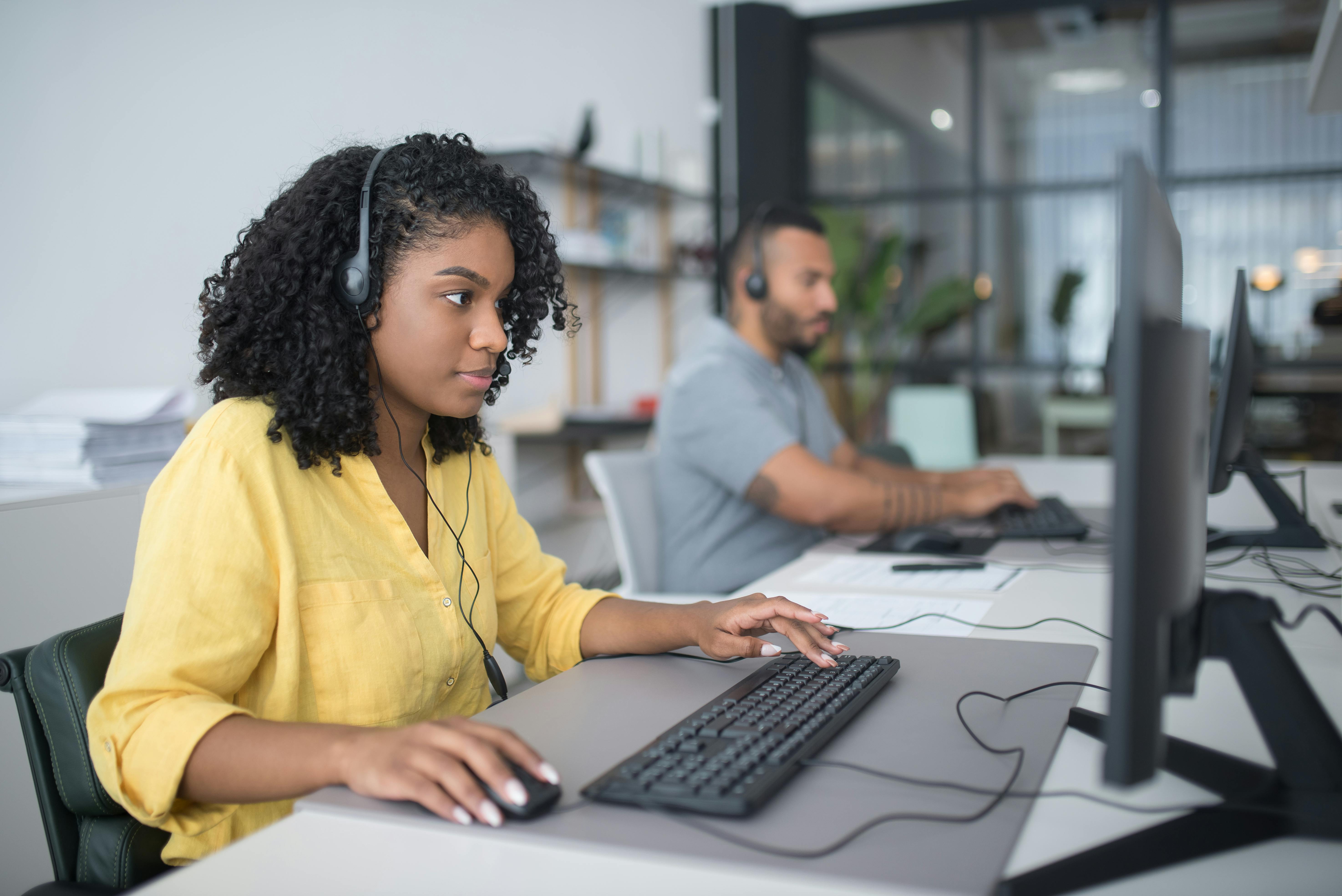 man standing in front of people sitting beside table with laptop computers