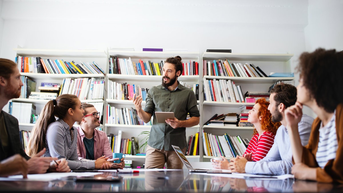 A group of mature students listening to a facilitation trainer during a seminar