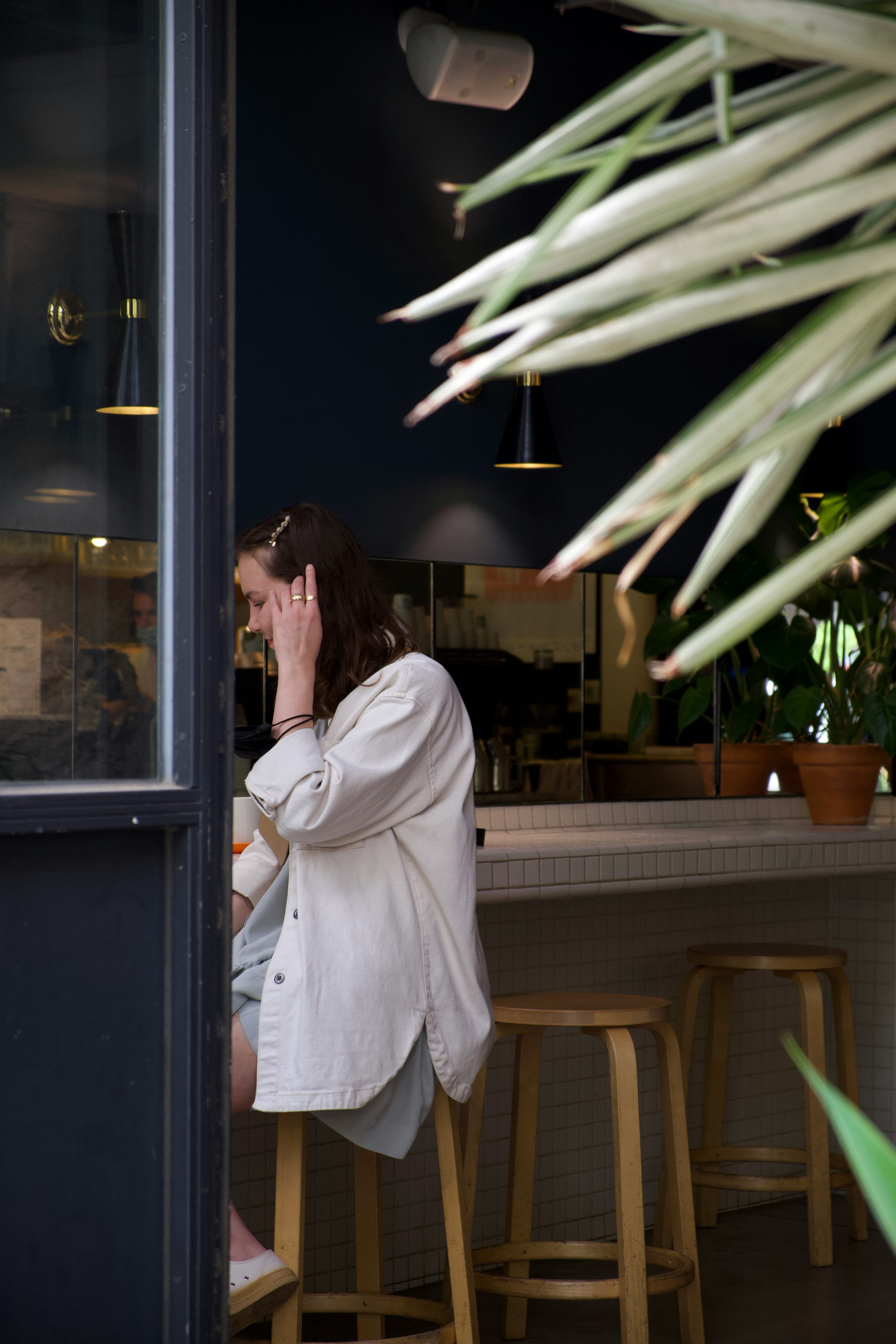Woman sitting at a bar counter in a café.