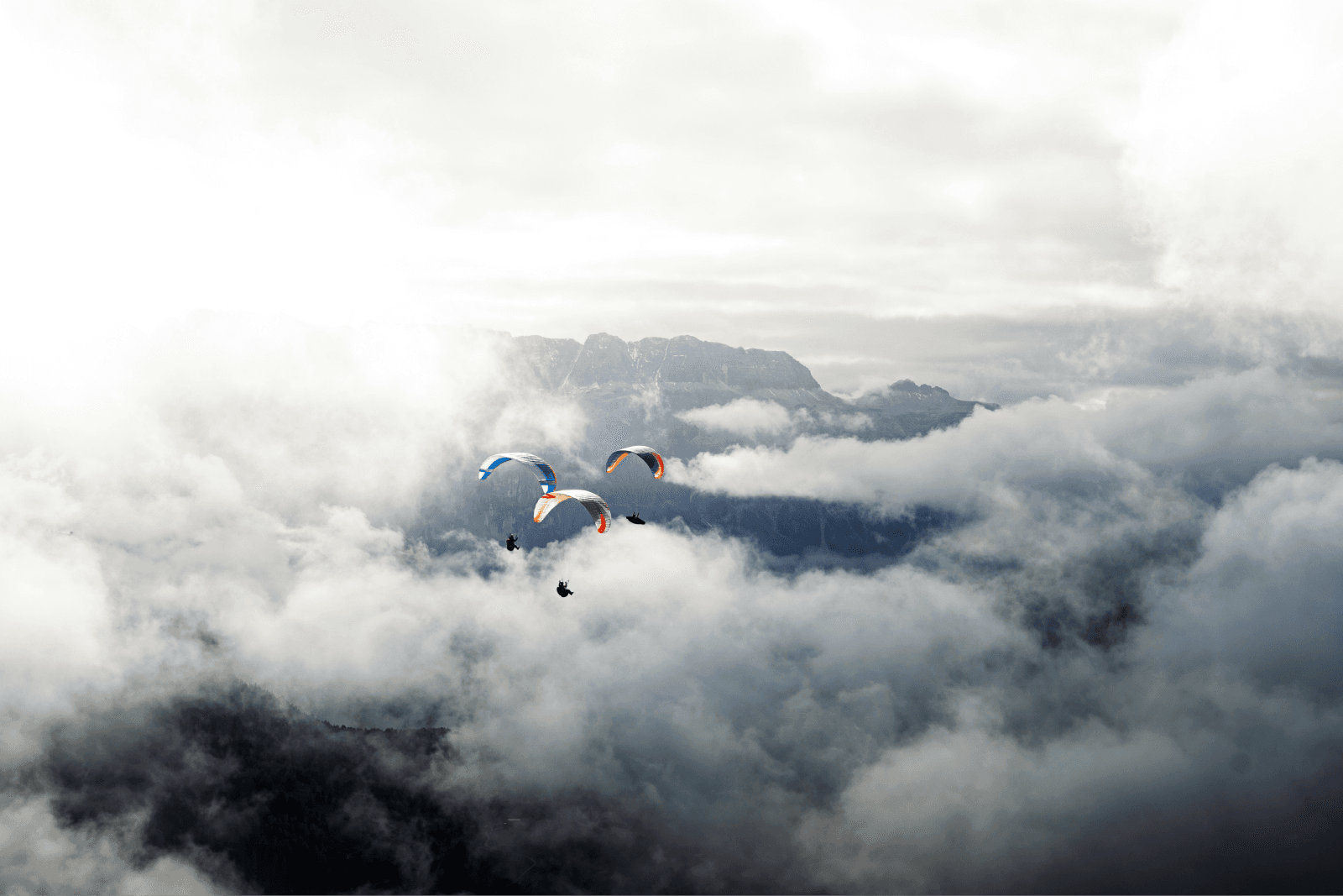 people parachuting over clouds