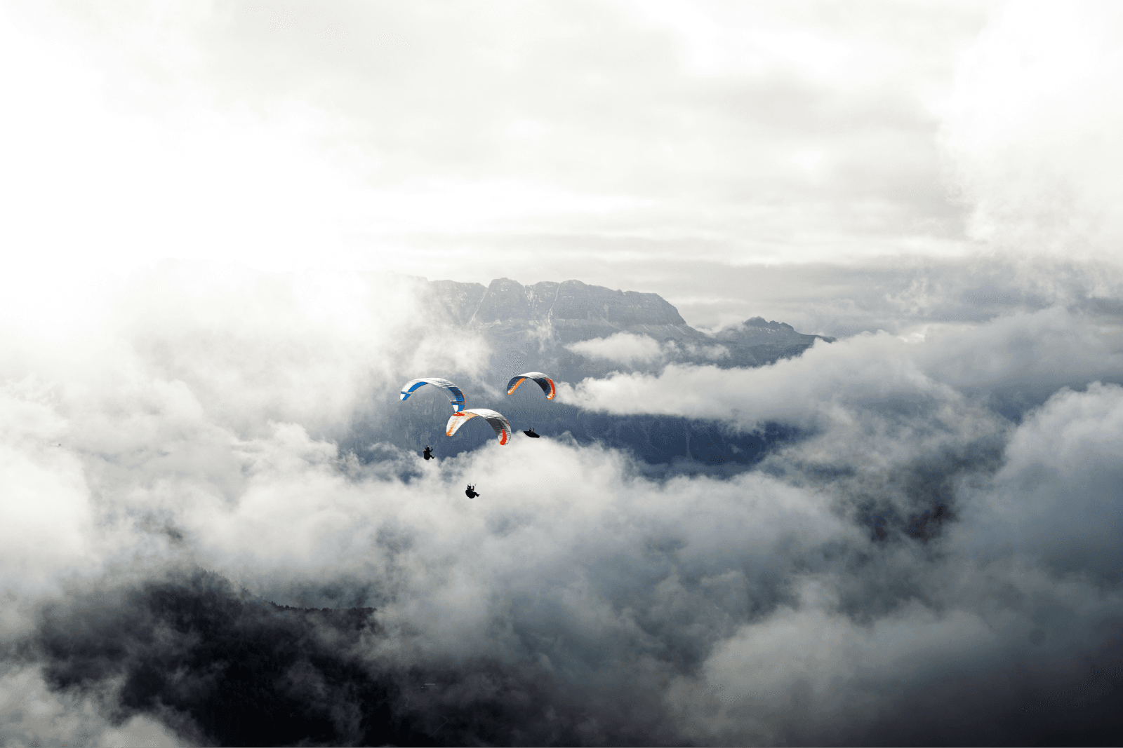 People parachuting over clouds