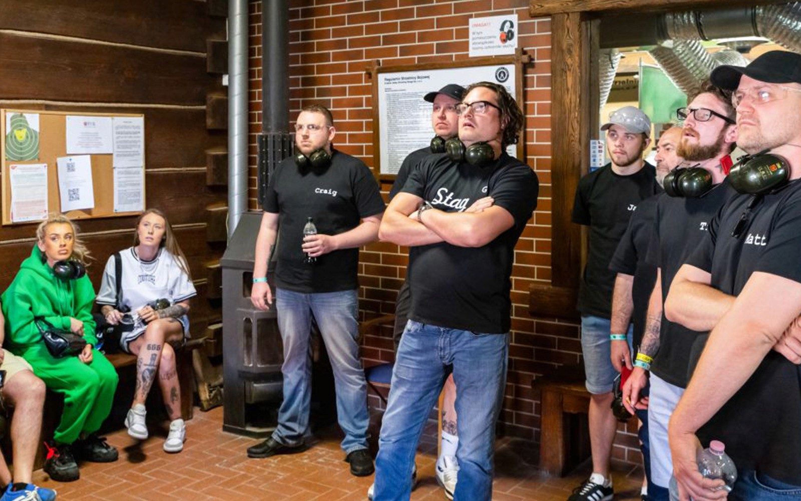 Groep mensen luistert naar instructies bij een indoor schietbaan.