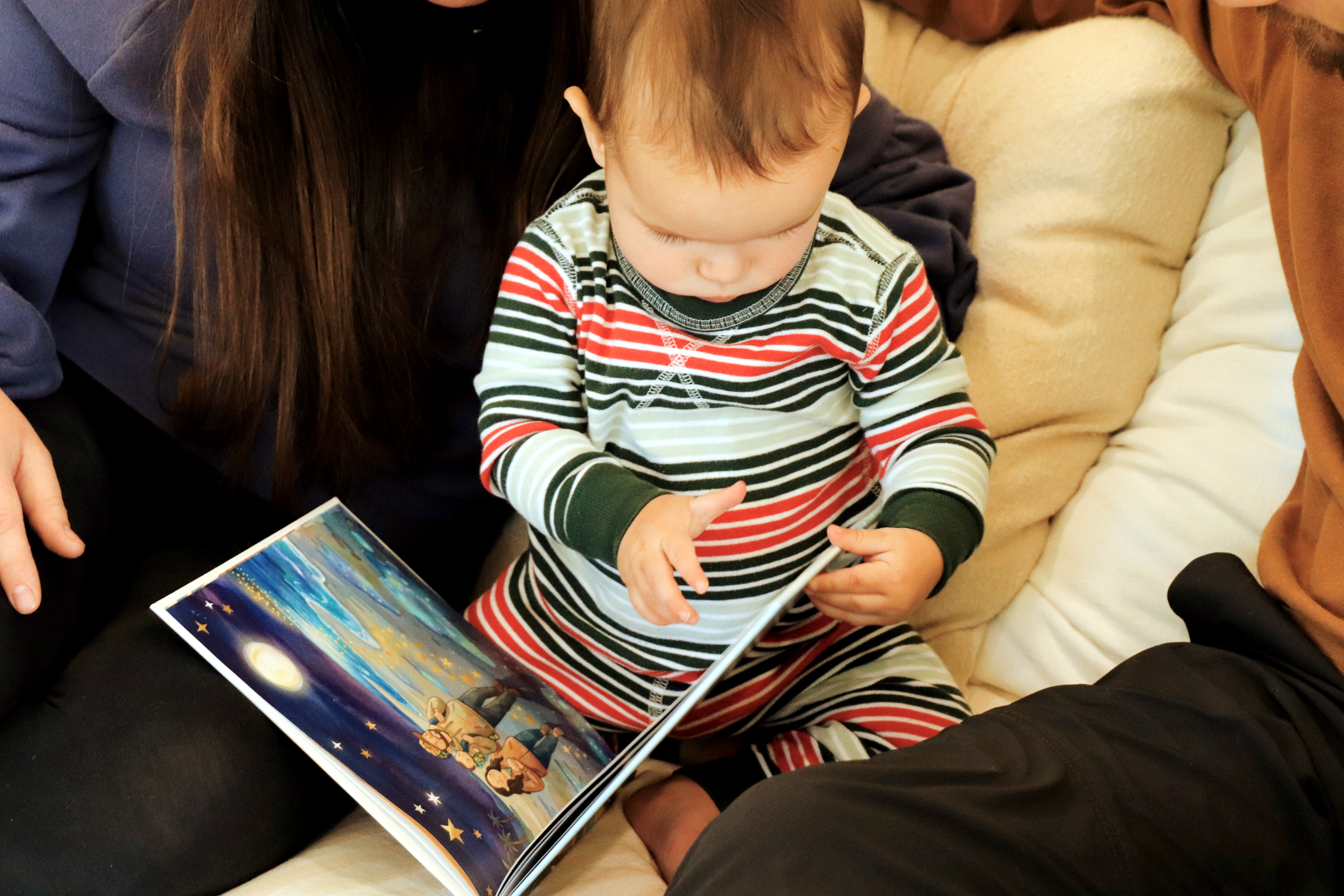 Smiling young woman with long hair standing against a dark green background, holding a finger to her chin.