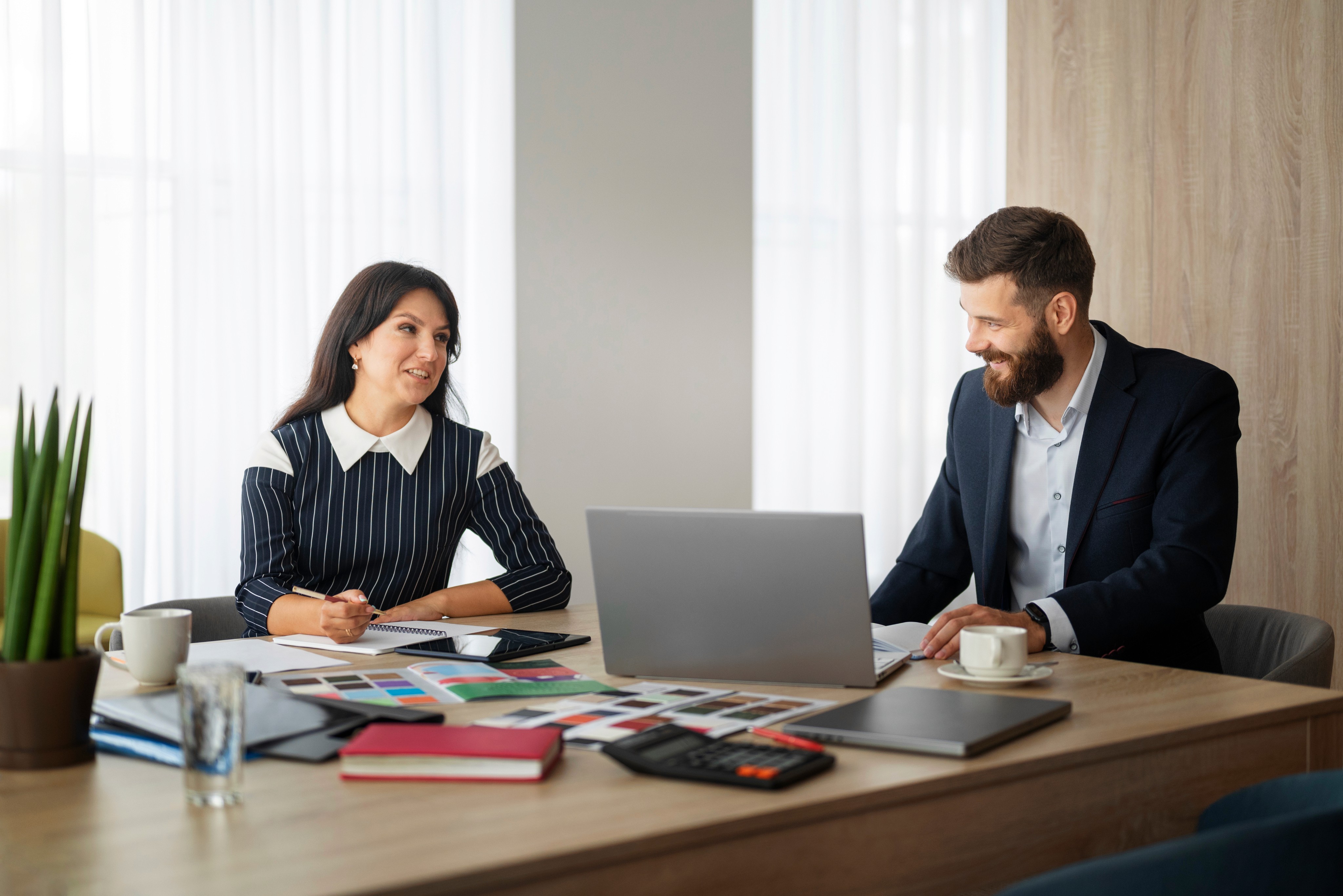 Professional man and woman collaborating on a project with laptop.