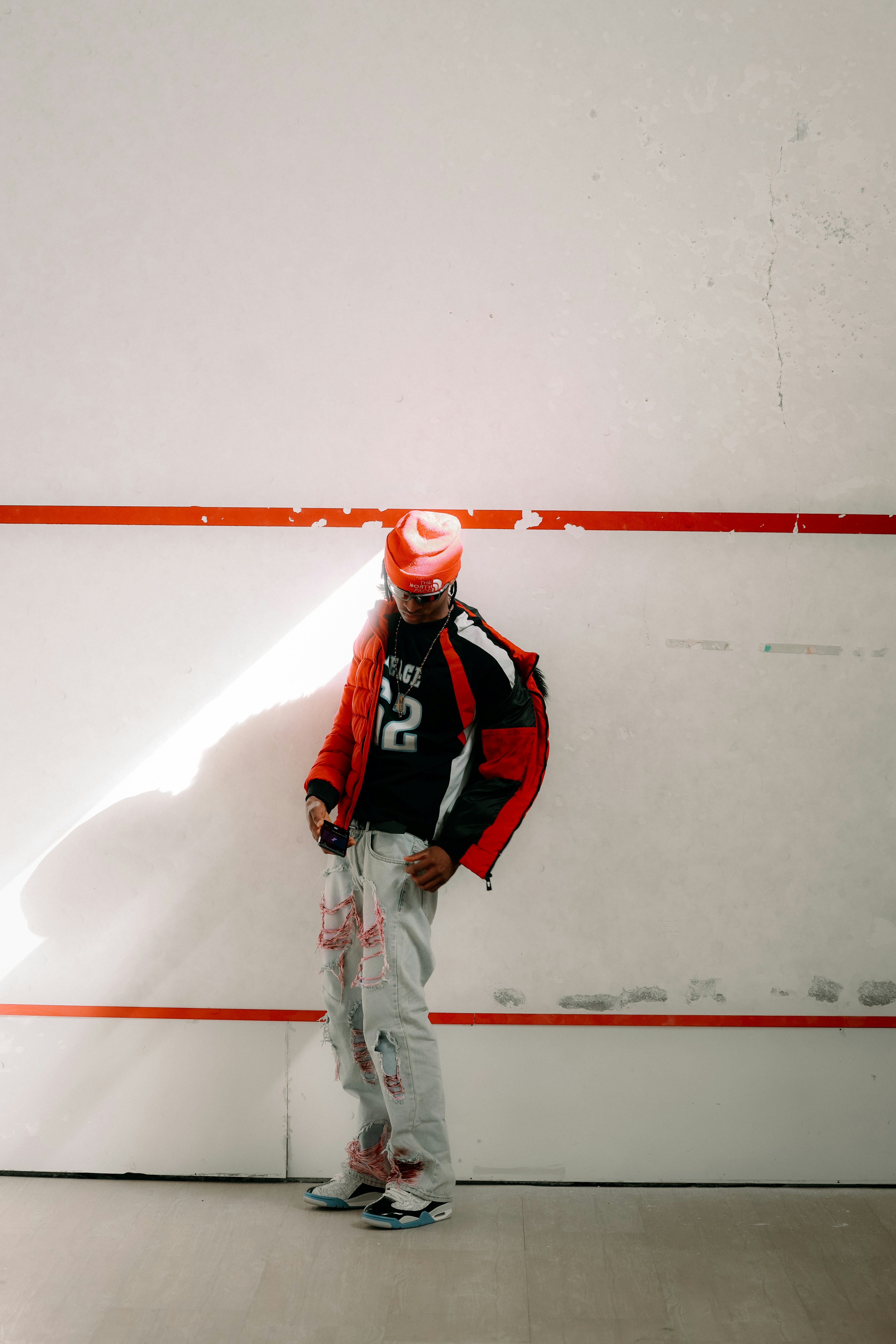 Man in red hat and jacket against white wall