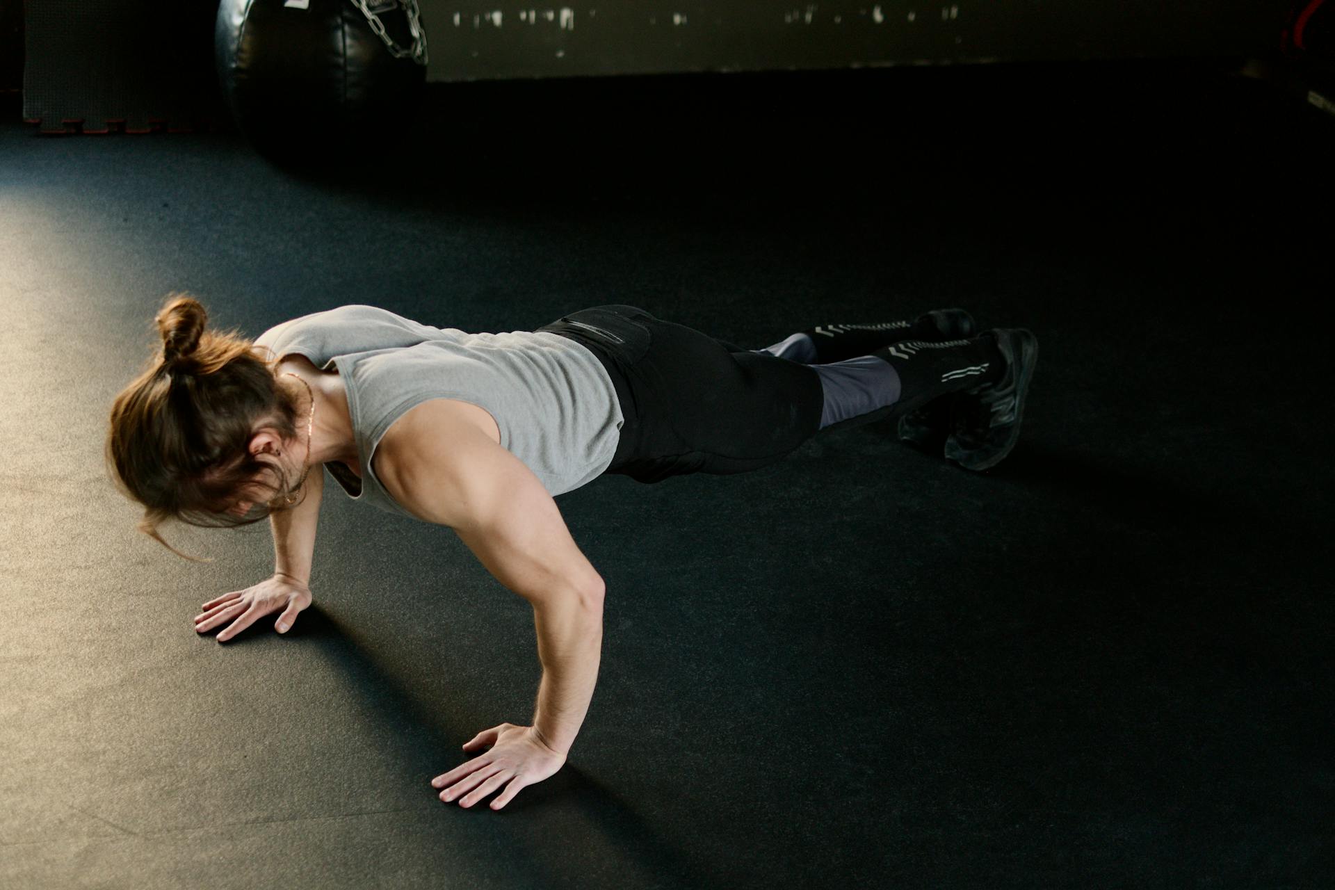 A woman doing push-ups on the gym floor to tone her arms