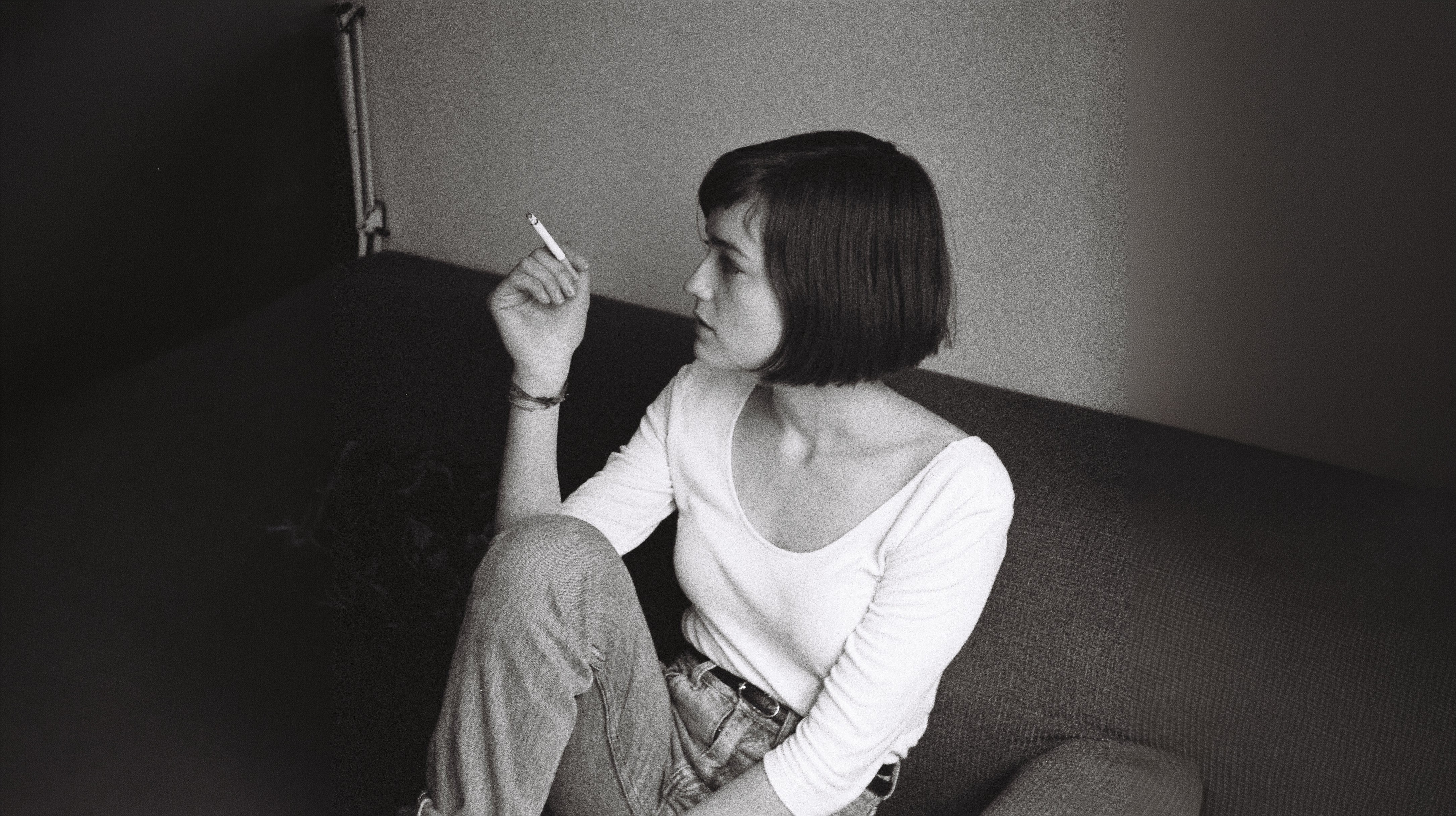 rtistic black and white portrait of a girl sitting on a sofa, photographed by Vera Marmelo.