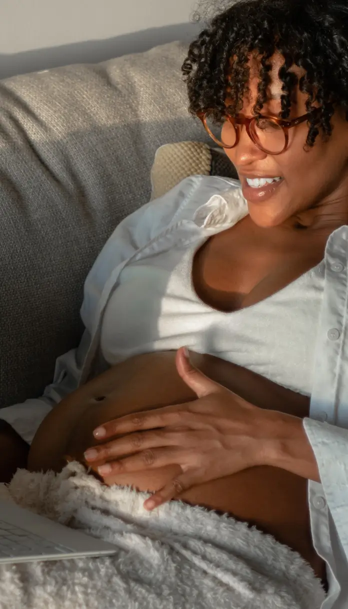 A woman named Jenny O with black hair smiles while sitting on a wooden surface, with shelves in the background.