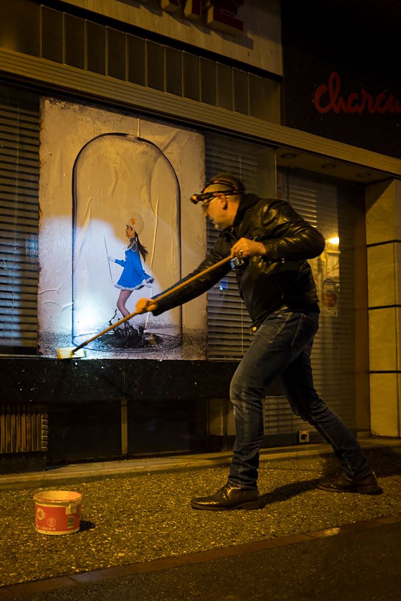 Frédéric Bourcier, photographe documentaire, avec sa fille devant une série de portraits en noir et blanc exposés sur les murs d’une galerie.