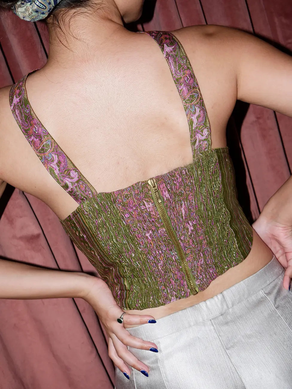 SITARA II cross-halter corset crafted from metallic-threaded vintage silk saree in jewel-toned green and pink with bold crisscross halter neckline